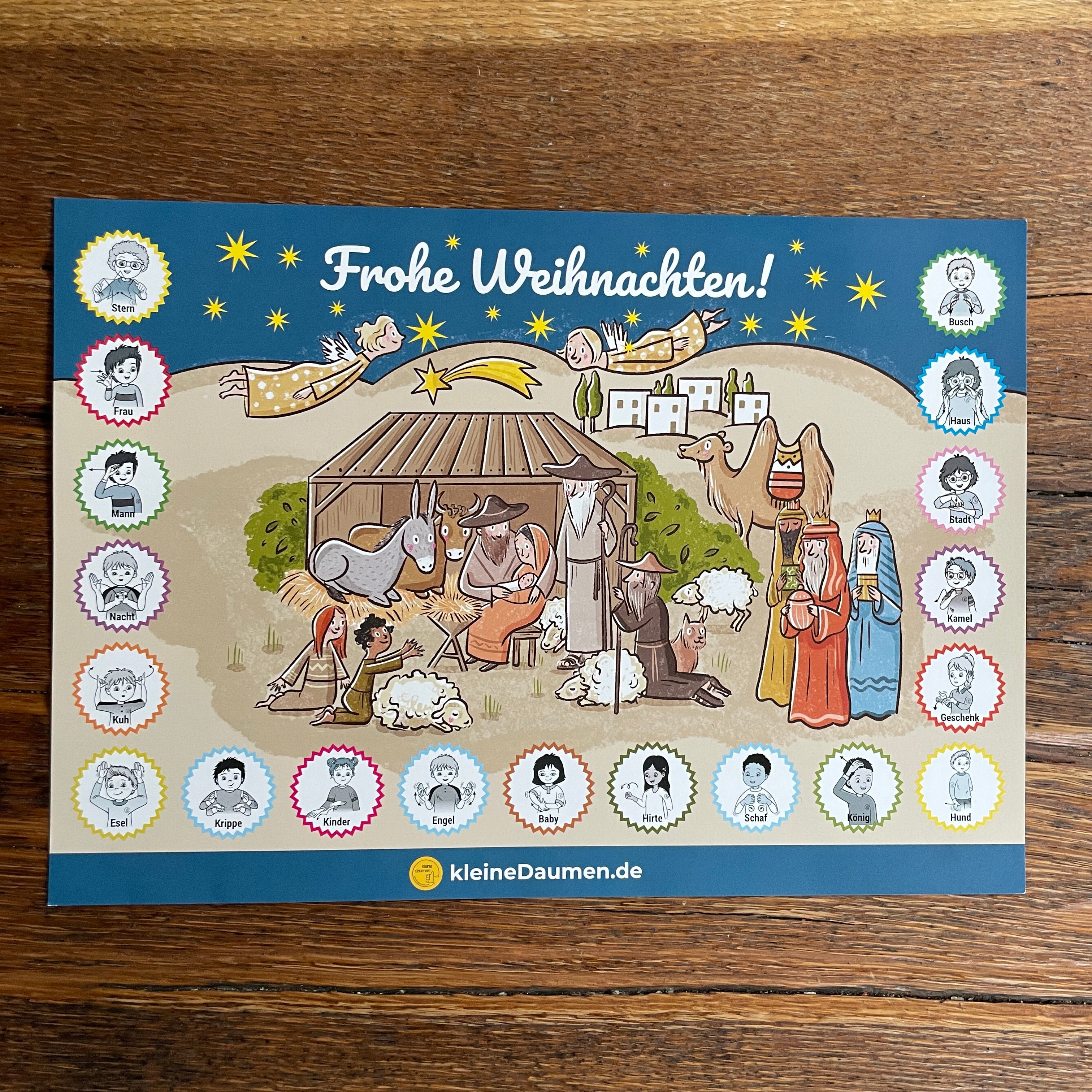 Eine farbenfrohe, illustrierte Krippenszene mit Maria, Josef, dem Jesuskind, Tieren, Hirten, Weisen und Engeln unter einem Sternenhimmel. Der Text Frohe Weihnachten! steht oben, umgeben von Cartoon-Gesichtern in Kreisen.
