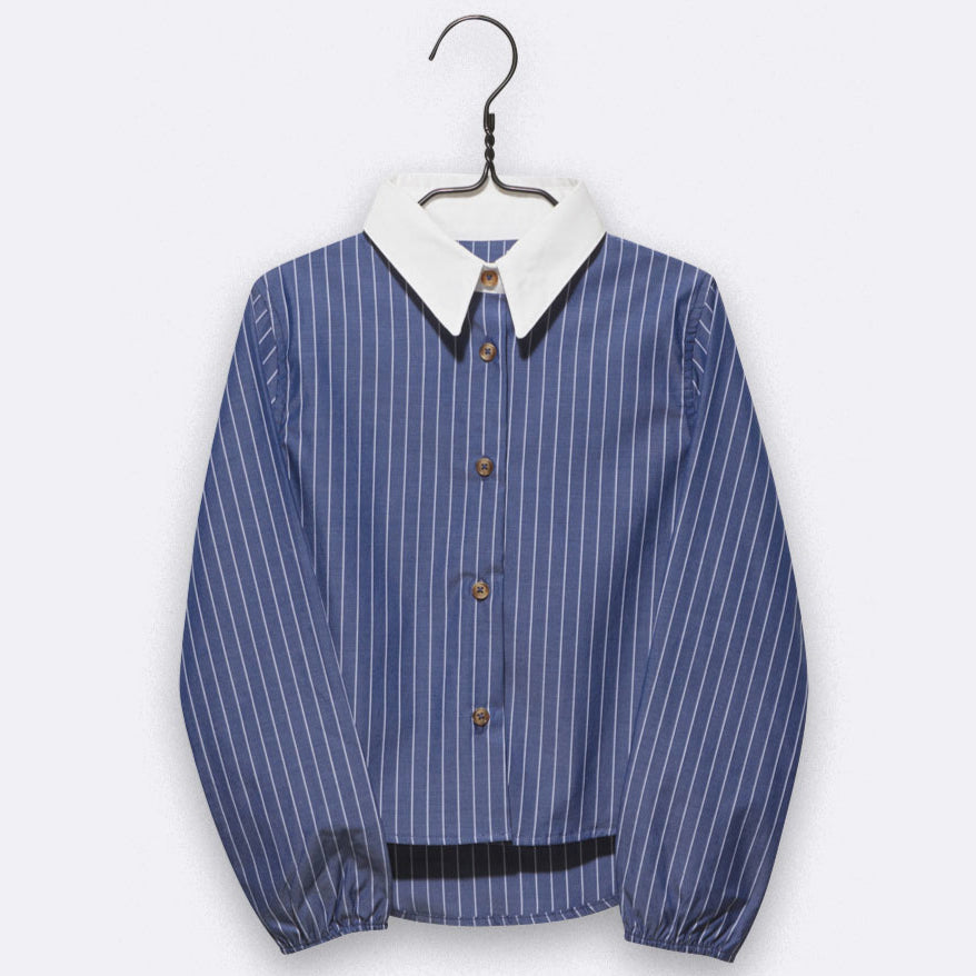 Eine blaue, langärmelige Bluse mit weißen vertikalen Nadelstreifen, braunen Knöpfen, weißem Spitzkragen und gerafften Manschetten, die auf einem Bügel vor einem schlichten weißen Hintergrund präsentiert wird.