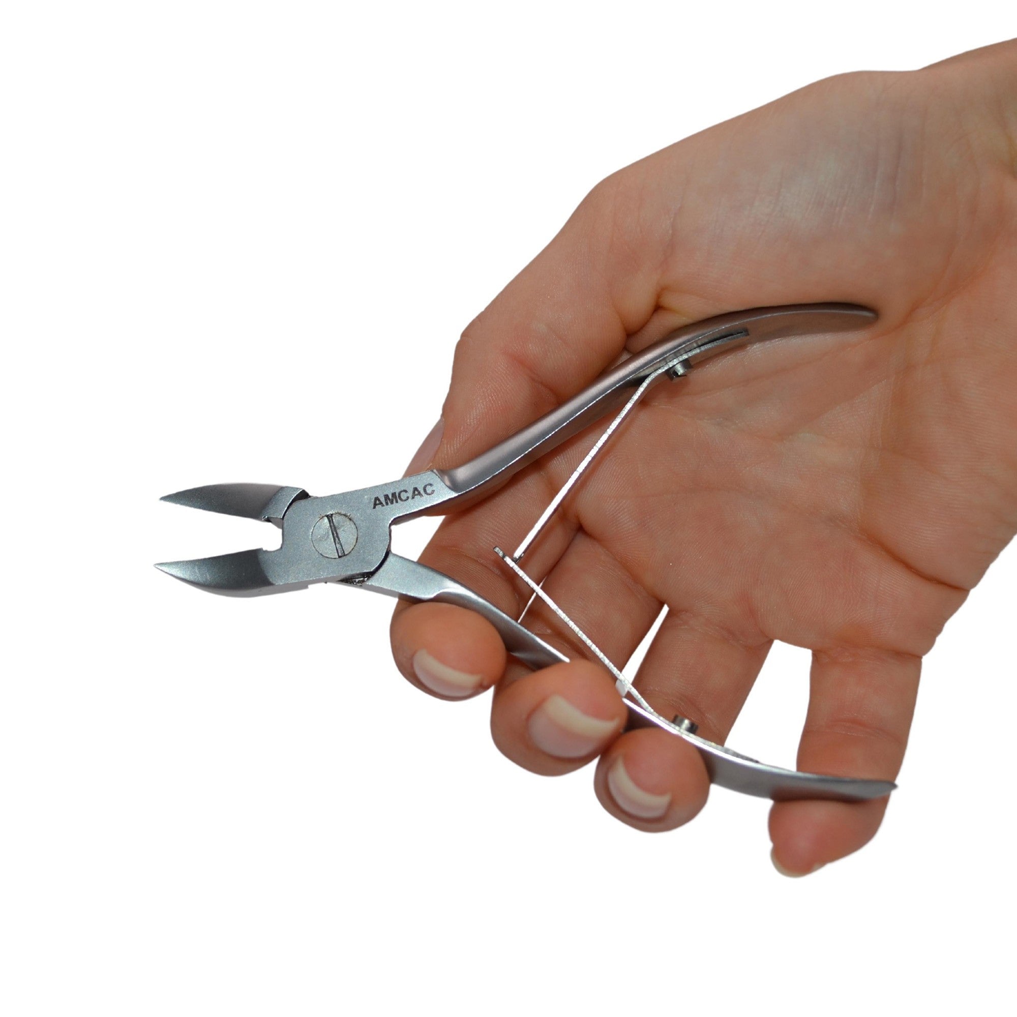 Eine Hand, die eine Nagelzange aus rostfreiem Stahl mit gebogenen Griffen und einem Federmechanismus hält, die zum Trimmen von Nägeln bestimmt ist.