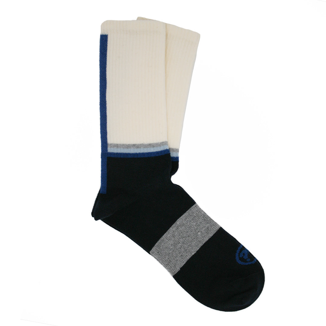 Ein Paar Socken in Weiß und Schwarz mit blauen und grauen Streifen, flach auf einer weißen Oberfläche liegend.