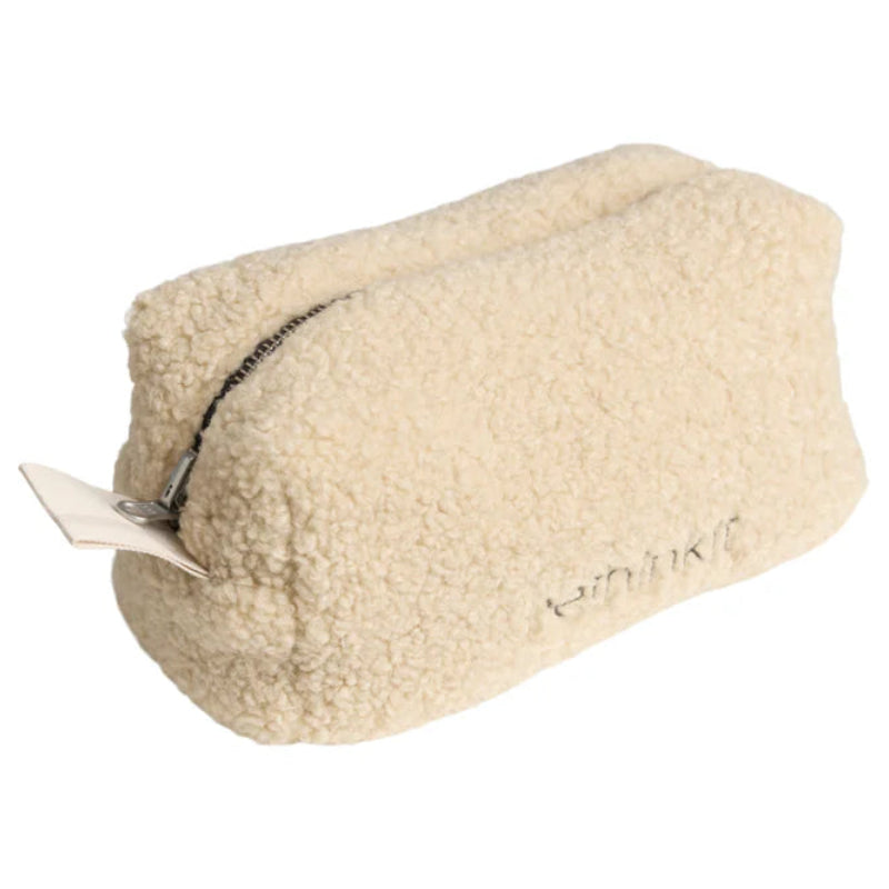 Eine rechteckige, cremefarbene Tasche mit einer weichen, strukturierten, fleeceartigen Außenseite und einem Reißverschluss.
