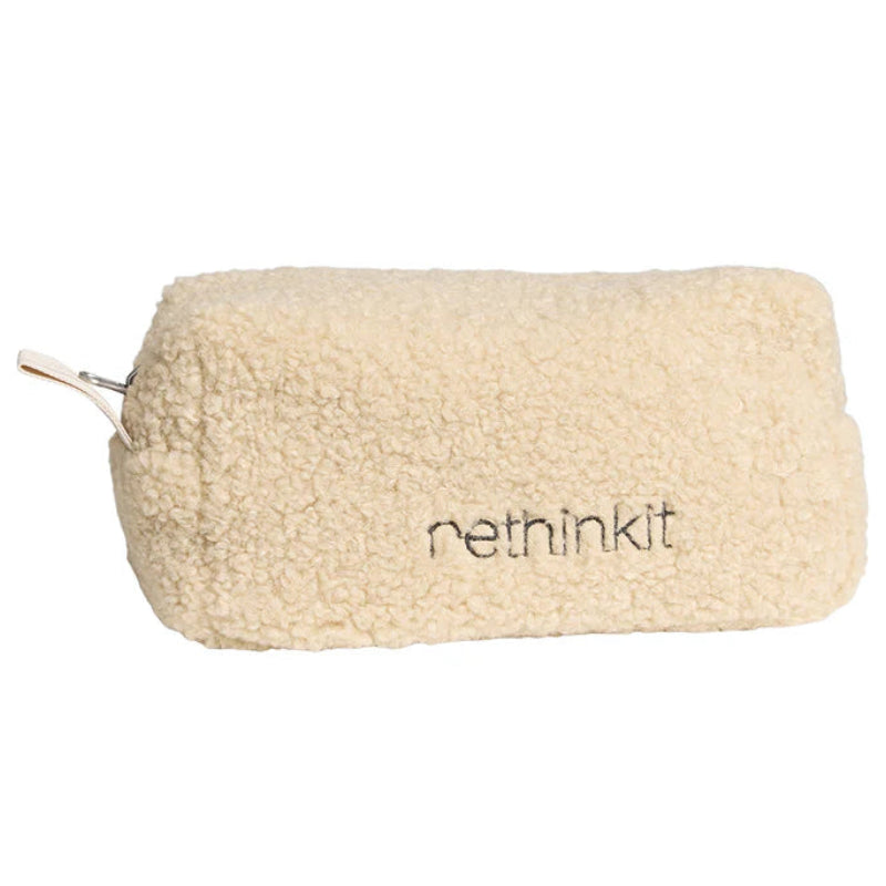 Eine rechteckige, cremefarbene Tasche aus weichem, strukturiertem Fleecematerial mit einem Reißverschluss und dem aufgestickten Wort rethinkit an der Seite.