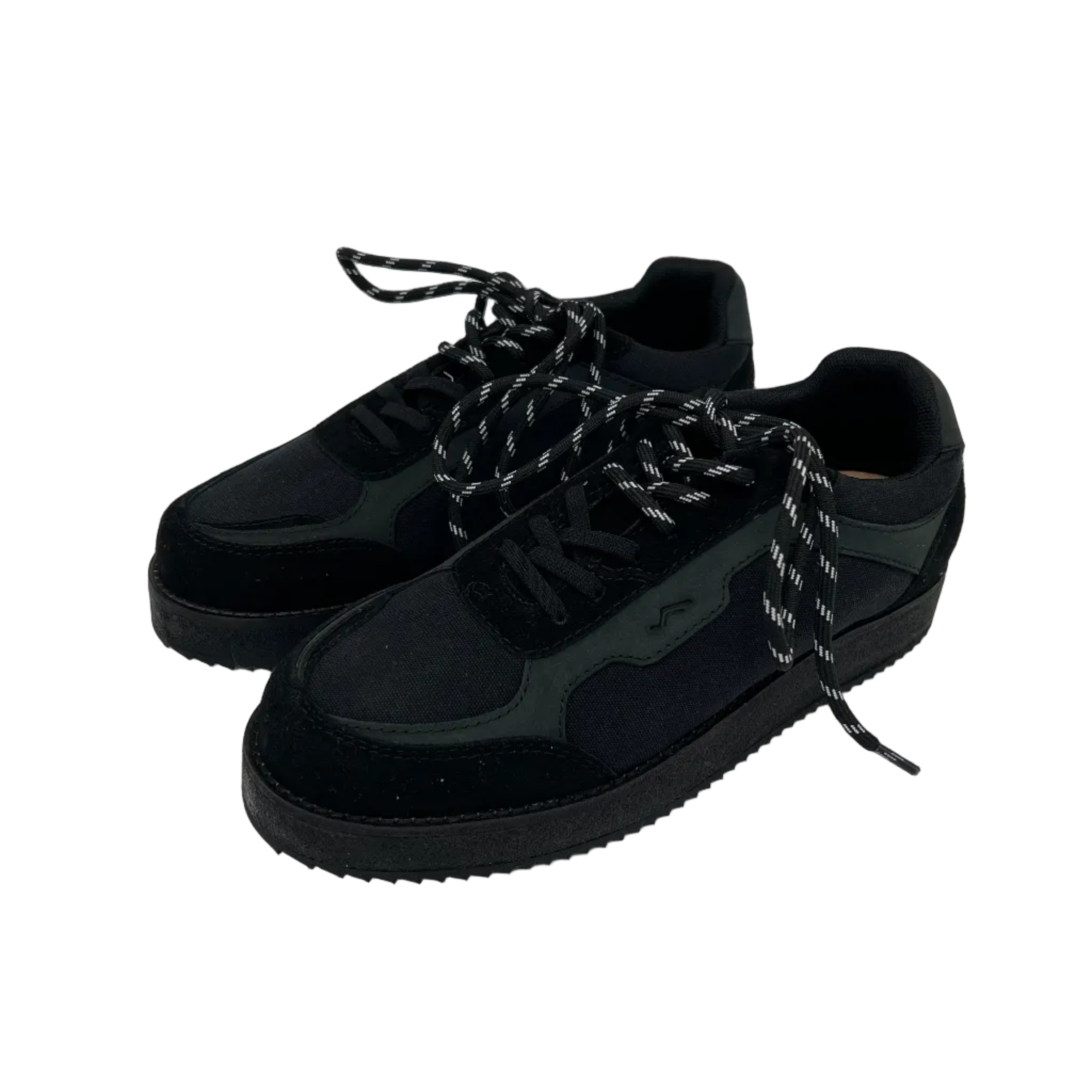 Ein Paar schwarze Turnschuhe mit strukturierten Sohlen, Wildleder- und Stoffeinsätzen und schwarz-weiß gemusterten Schnürsenkeln auf weißem Hintergrund.