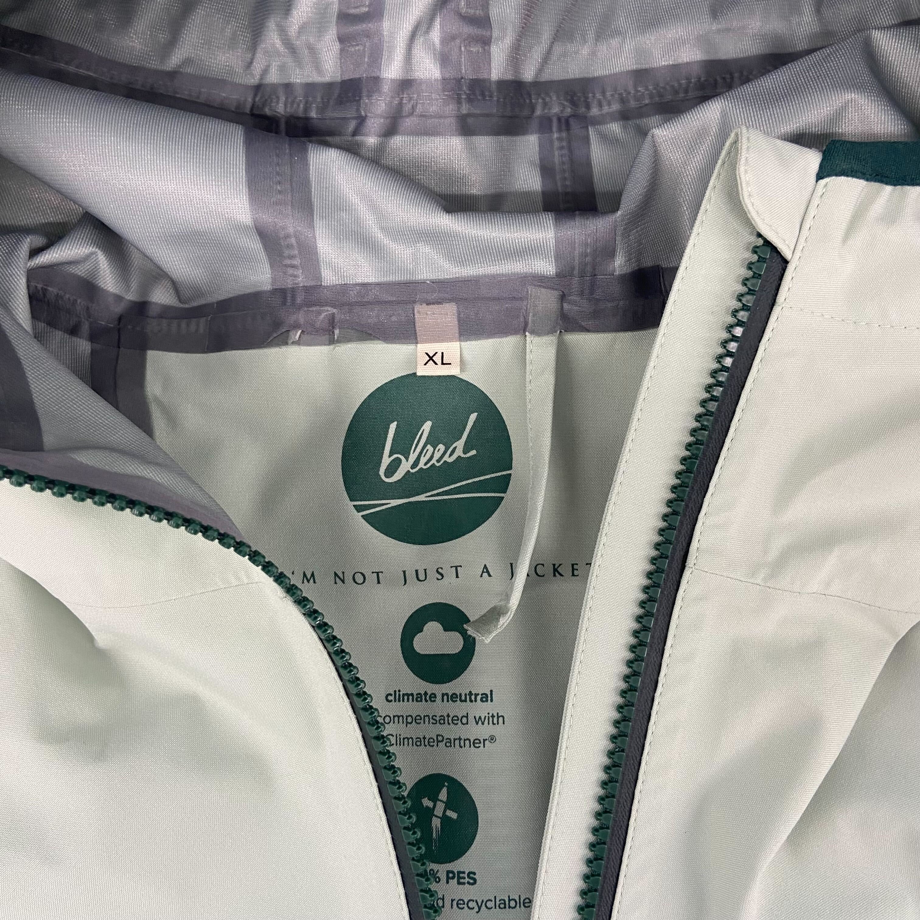 Innenansicht einer Jacke mit grünem Etikett „bleed“ in Größe XL, klimaneutral und recycelbar ausgezeichnet.