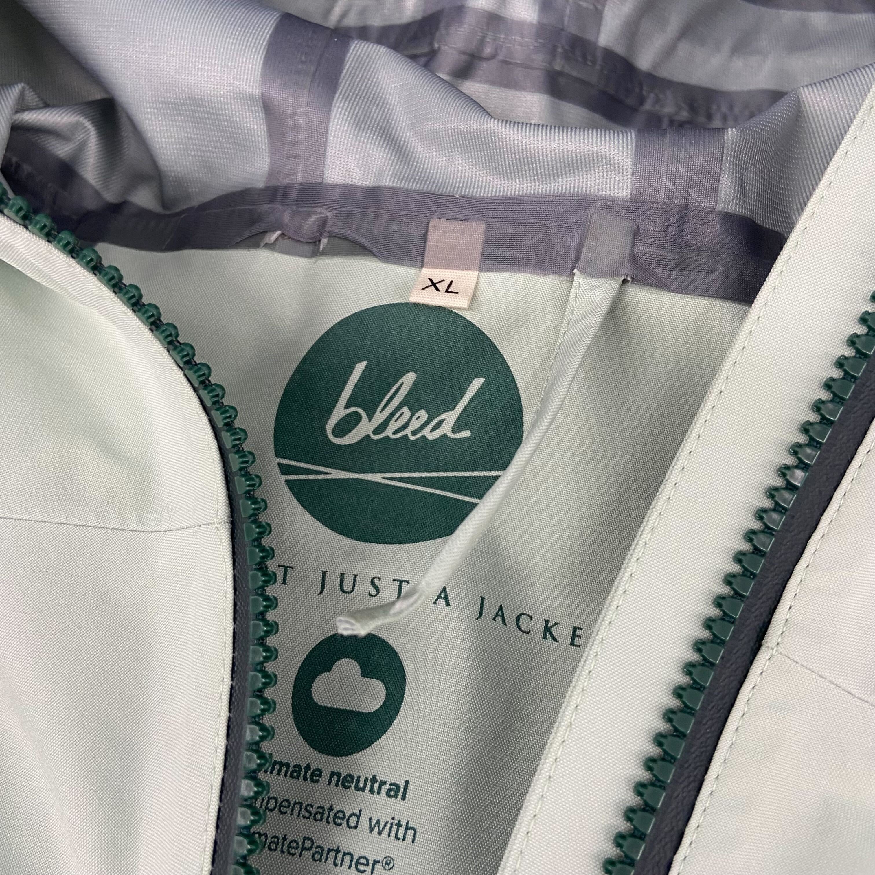 Nahaufnahme des Etiketts einer Jacke mit der Aufschrift „bleed“ und Größe „XL“.