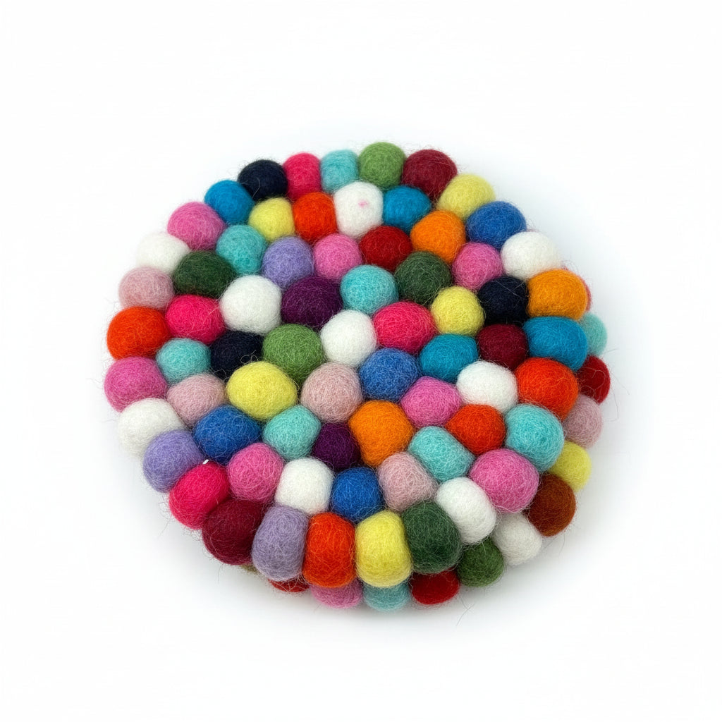 Ein runder Untersetzer aus bunten Filzkugeln wird auf eine Holzoberfläche gelegt. Die Kugeln sind dicht in einem kreisförmigen Muster angeordnet, wodurch ein lebendiges und strukturiertes Aussehen entsteht.