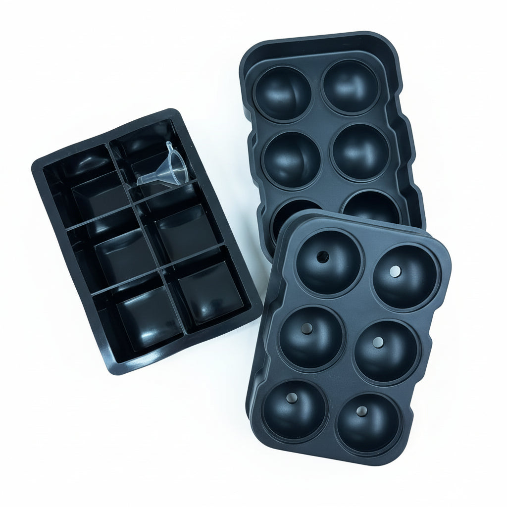 Abgebildet sind drei schwarze Silikoneisformen: eine mit sechs kugelförmigen Vertiefungen, eine andere mit acht quadratischen Fächern und ein kleiner Trichter, der in die quadratische Form eingesetzt wird. Alle sind auf weißem Hintergrund abgebildet.