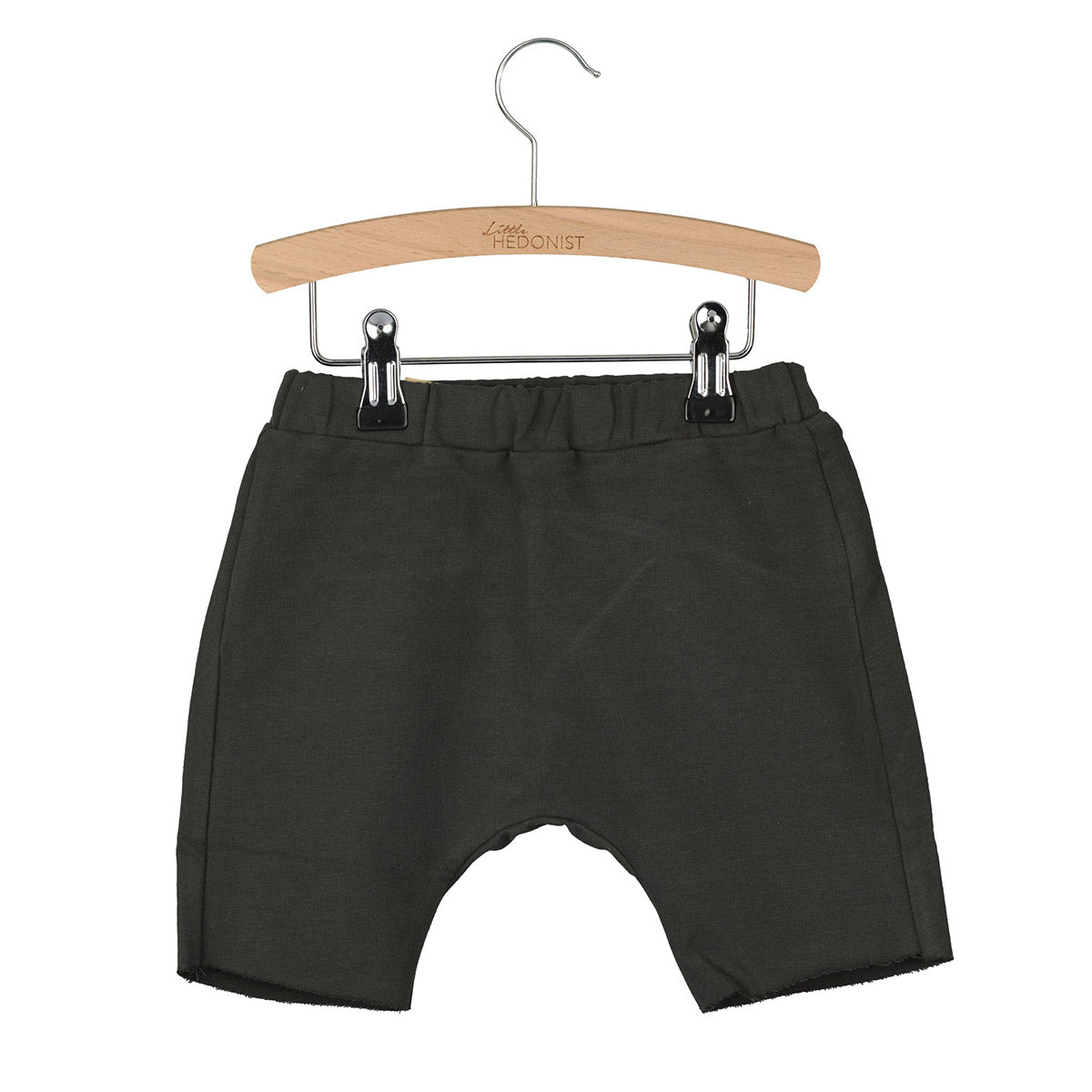 Ein Paar dunkelgraue Baby-Shorts mit einem elastischen Bund, die auf einem Holzbügel vor einem weißen Hintergrund hängen.
