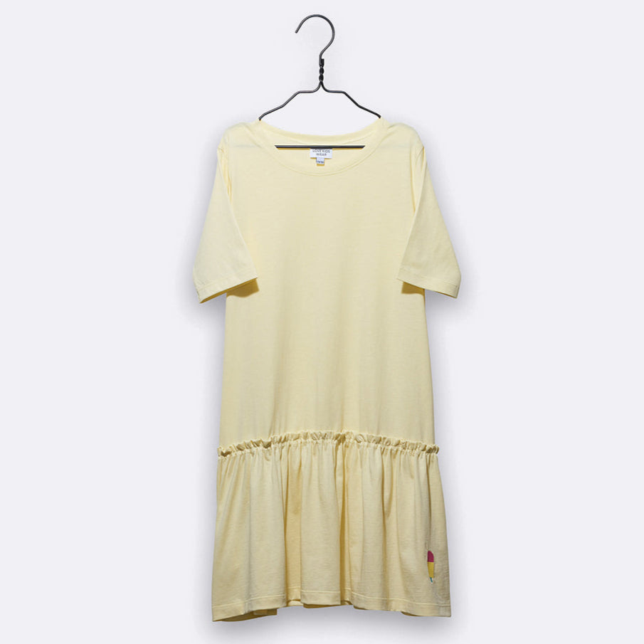 Ein hellgelbes, kurzärmeliges Kleid mit einem gerafften Saum über dem Saum, das auf einem Bügel vor einem schlichten, hellgrauen Hintergrund ausgestellt ist.