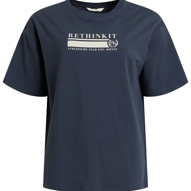 Ein marineblaues Kurzarm-T-Shirt mit dem Text RETHINK IT und ATHLEISURE CLUB EST. MMXXI in weißer Schrift auf der Vorderseite sowie einem kleinen runden Logo mit den Buchstaben RS.