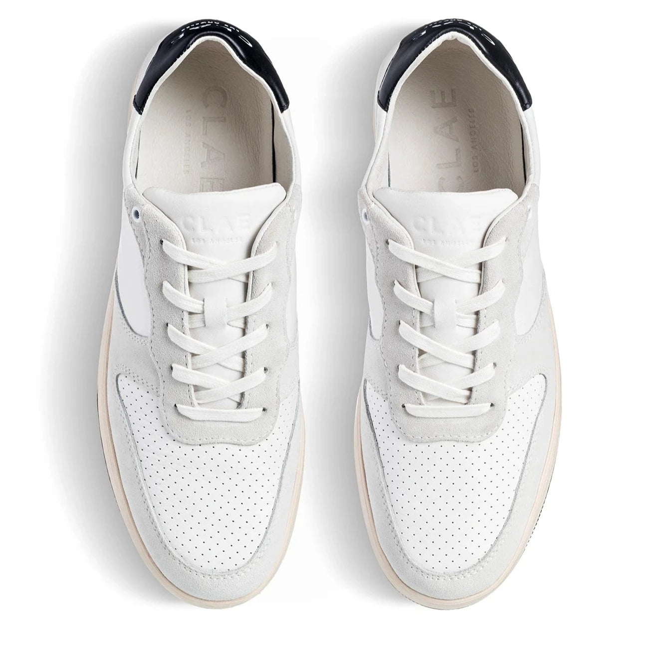 Weiße und graue Sneaker mit schwarzen Akzenten, aus der Vogelperspektive betrachtet.