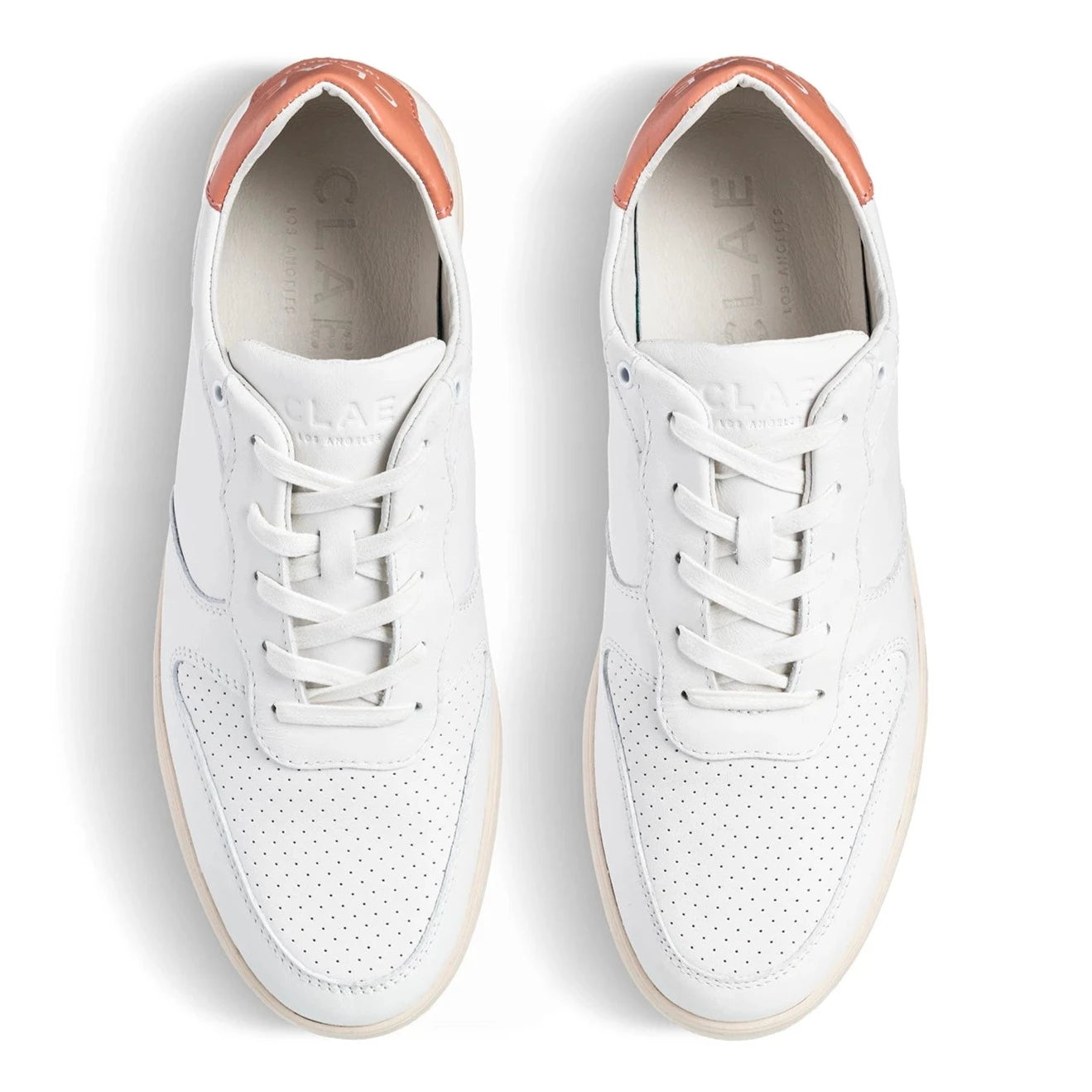 Weiße Sneakers mit perforierten Oberflächen und orangefarbenen Details an der Ferse, von oben betrachtet.