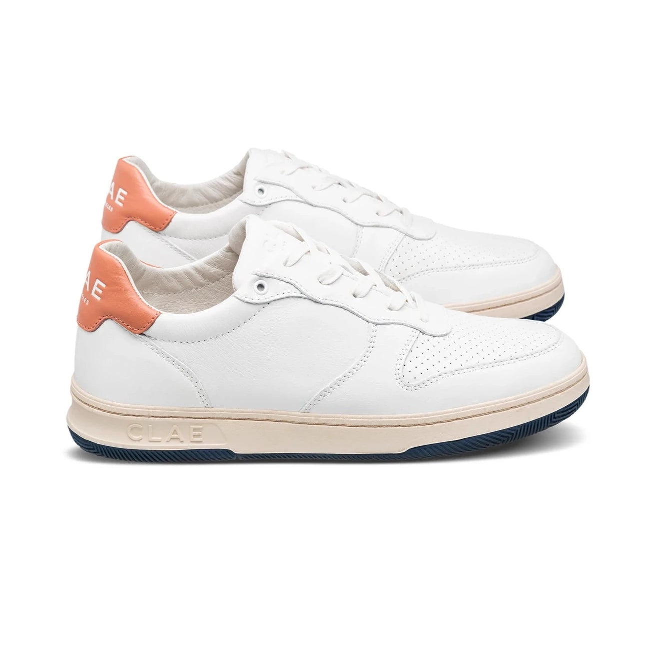 Weiße Sneaker mit beiger Sohle und orangefarbenem Fersenbereich, von der Seite fotografiert.