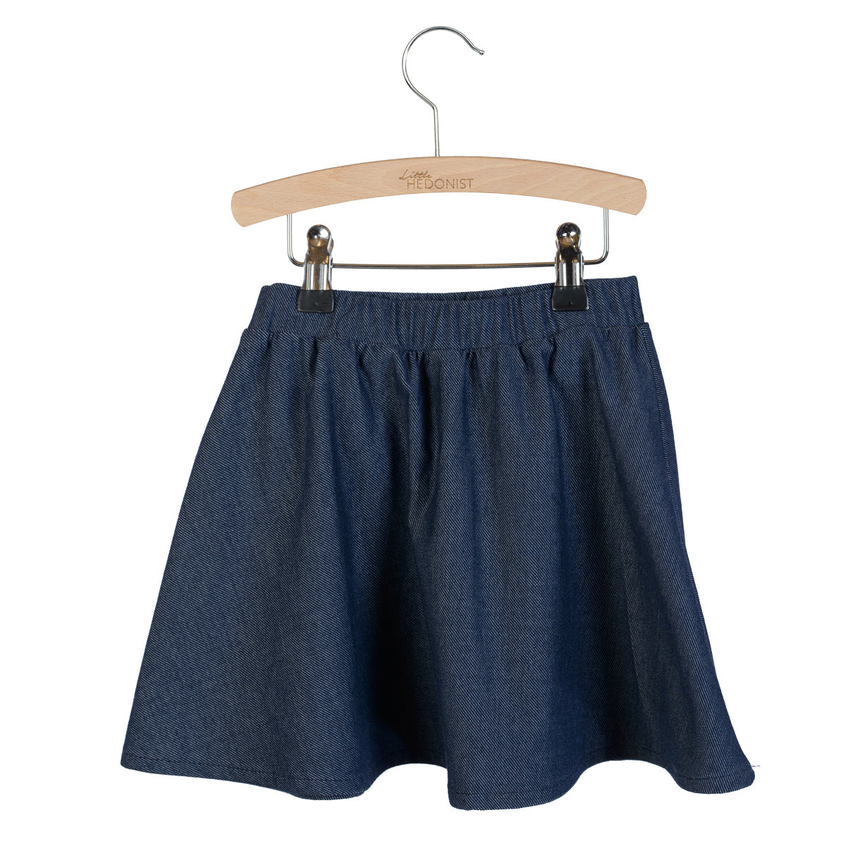 Ein blauer Jeansrock mit elastischem Bund, ausgestellt auf einem Holzbügel vor einem weißen Hintergrund.
