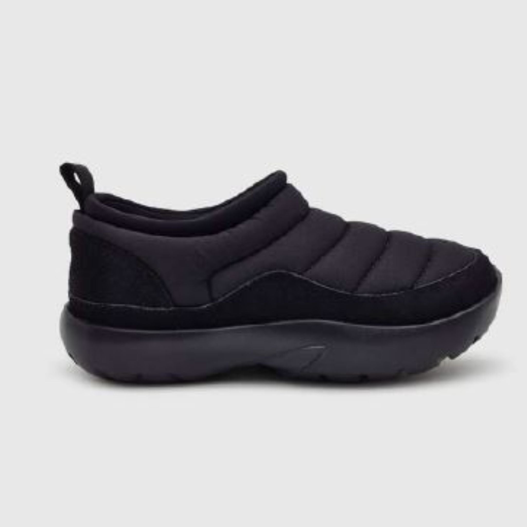 Ein einzelner schwarzer Schlupfschuh mit einer dicken, gepolsterten Sohle und einem gesteppten, gepolsterten Schaft auf hellgrauem Hintergrund. Der Schuh hat eine Zuglasche an der Ferse.