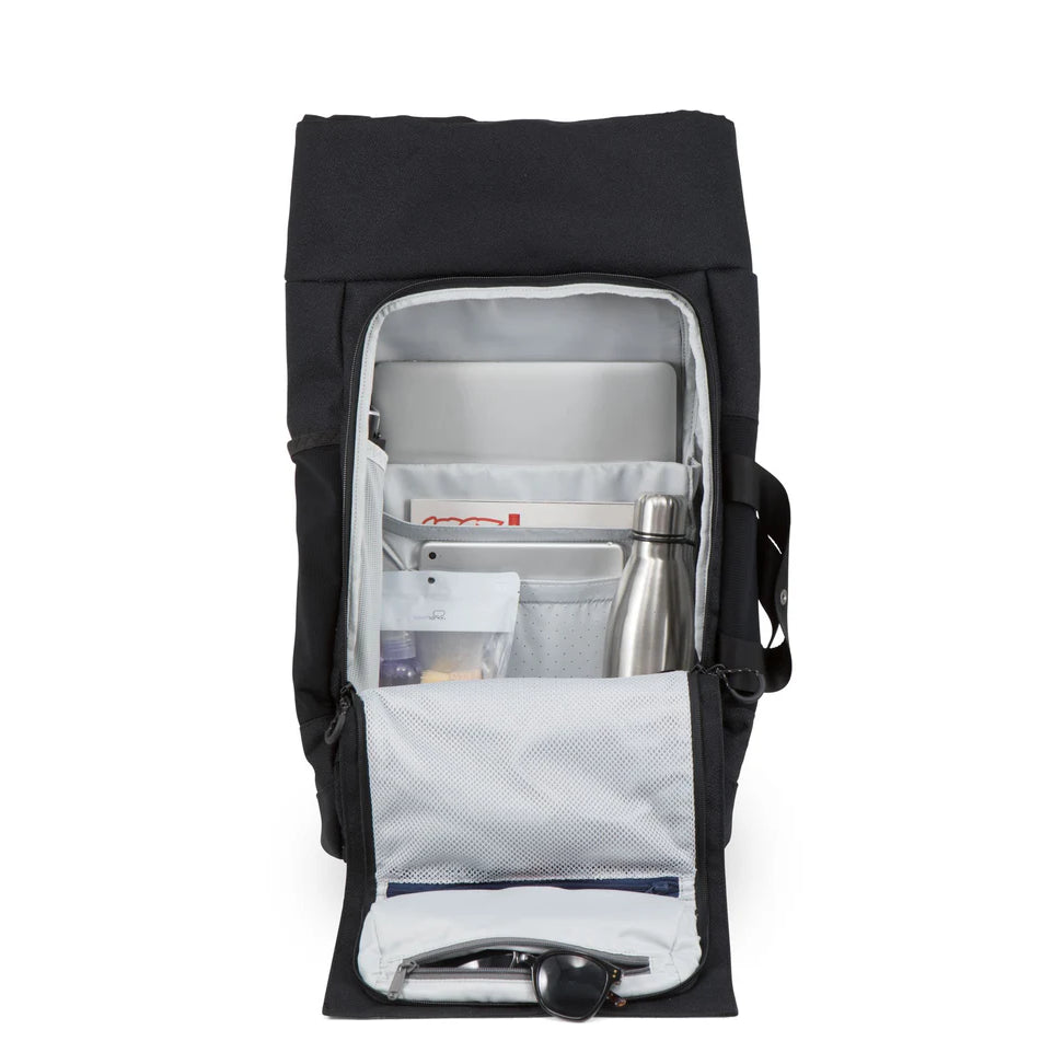 Ein schwarzer Rucksack, dessen obere Klappe geöffnet ist und der geordnete Fächer für einen Laptop, eine Zeitschrift, eine Wasserflasche aus rostfreiem Stahl, Stifte und verschiedene Dinge des täglichen Bedarfs enthält.