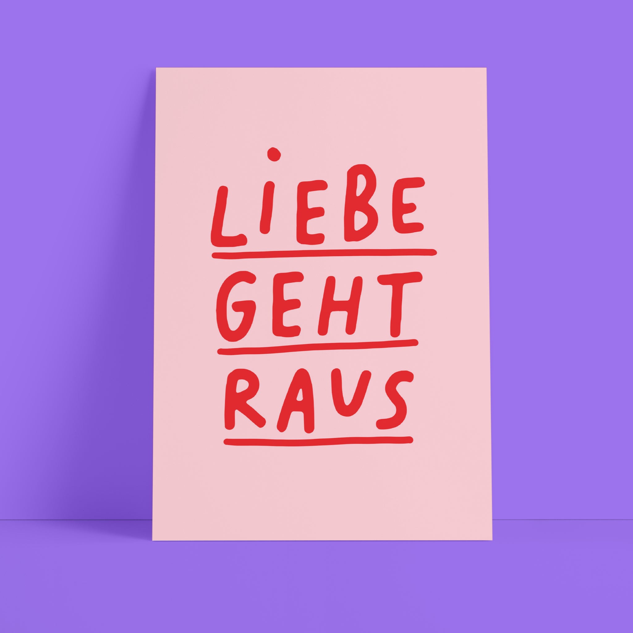 Eine rosafarbene Karte mit den deutschen Worten Liebe geht raus in fetten roten Buchstaben auf einem lila Hintergrund.
