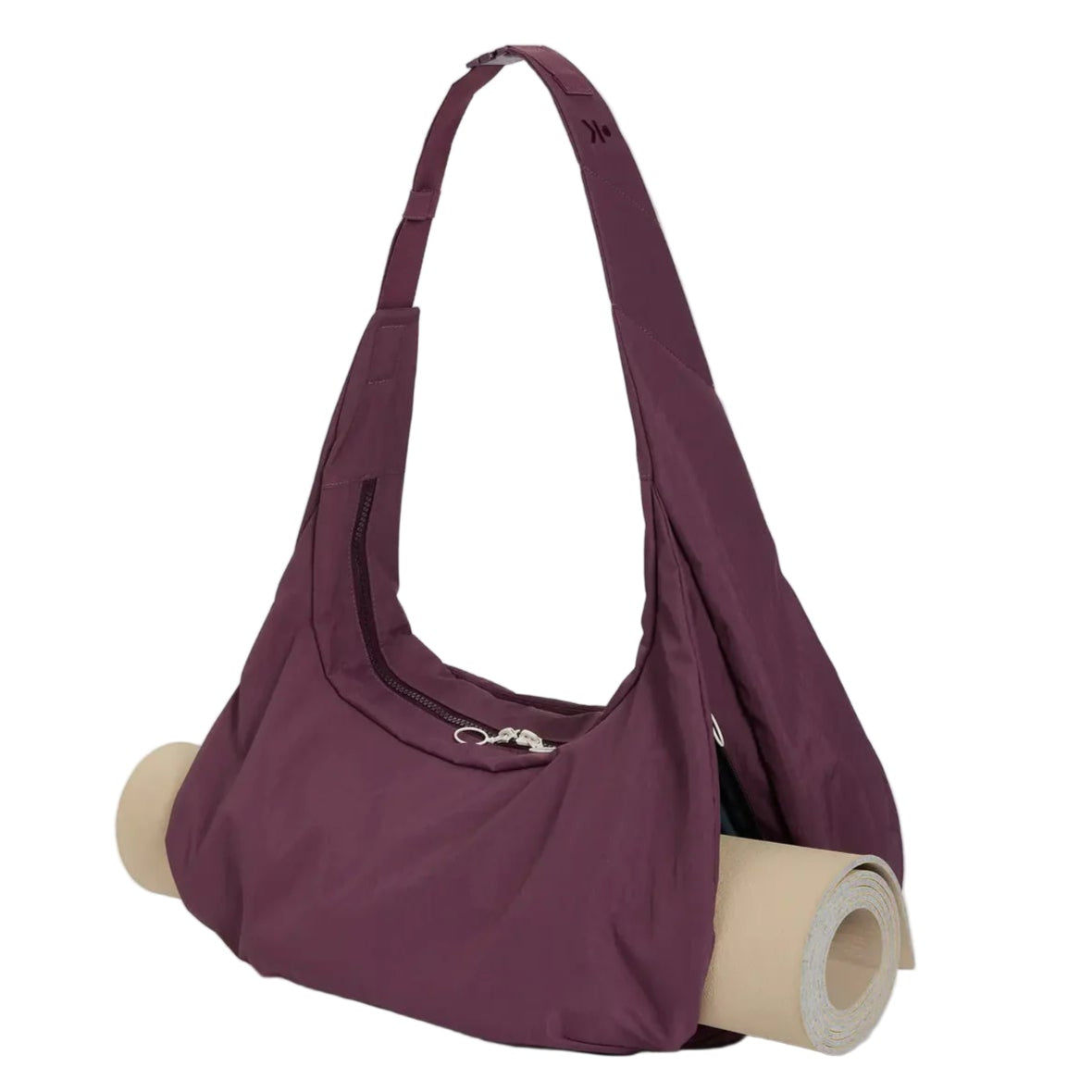 Eine lilafarbene Umhängetasche mit einem breiten Riemen und einer Reißverschlusstasche, in der eine aufgerollte Yogamatte in einem speziellen Fach am Boden aufbewahrt wird. Der Hintergrund ist einfarbig weiß.
