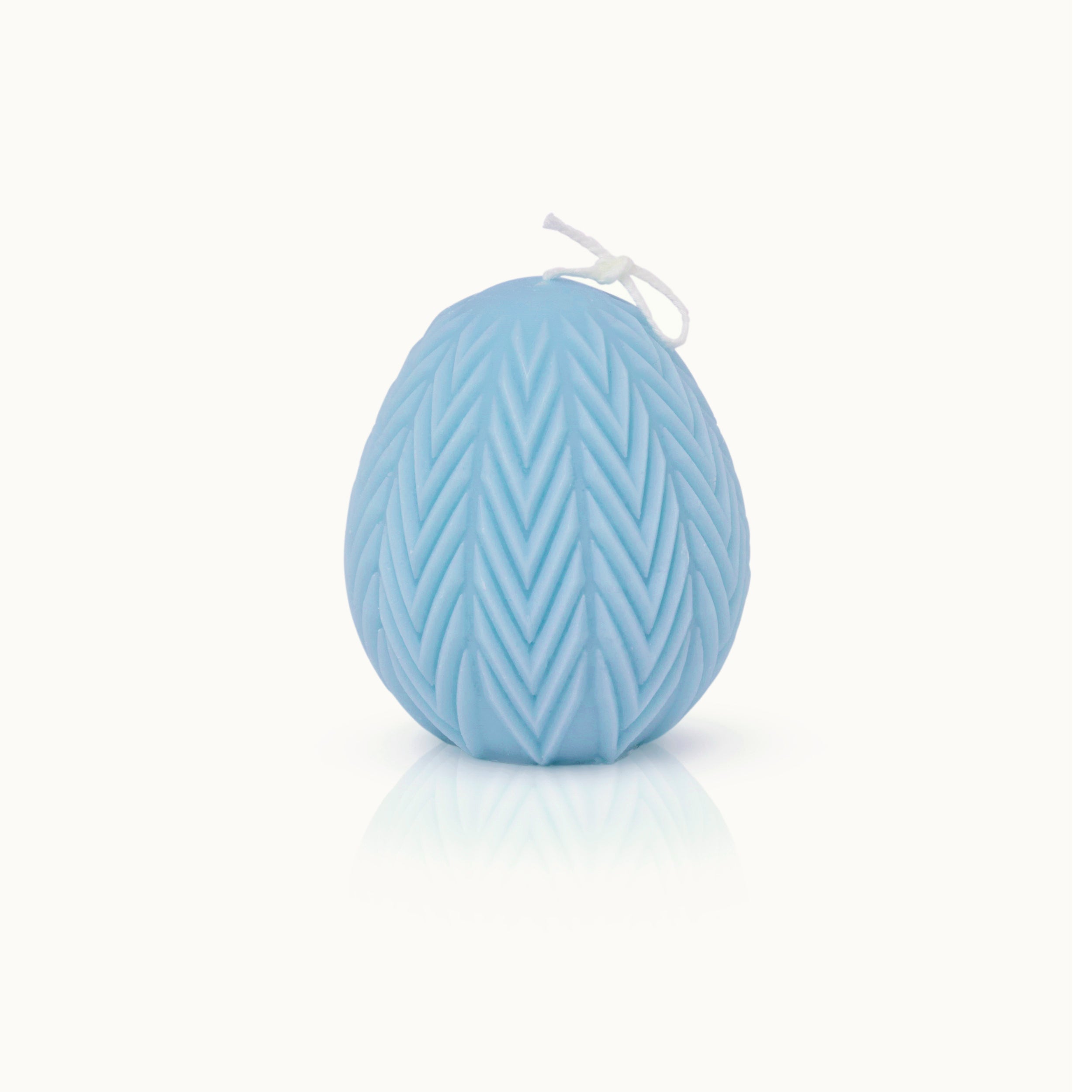 Eine hellblaue, eiförmige Kerze mit einem strukturierten Chevron-Muster und einem weißen Docht vor einem schlichten weißen Hintergrund.