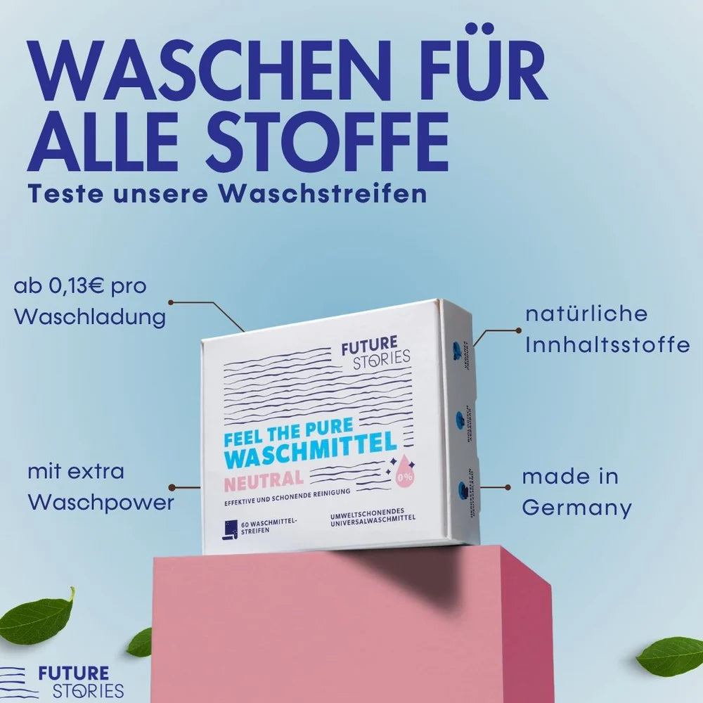 Eine Schachtel FUTURE STORIES Waschmittelstreifen steht auf einem rosafarbenen Block, umgeben von deutschem Text, der Merkmale wie natürliche Inhaltsstoffe, Made in Germany und zusätzliche Waschkraft hervorhebt.