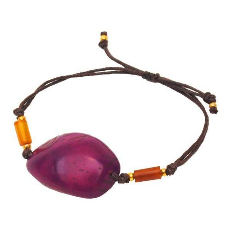 Ein Armband mit einem großen, glatten, violetten Stein in der Mitte, akzentuiert durch kleine bernsteinfarbene zylindrische Perlen und braune verstellbare Schnur.