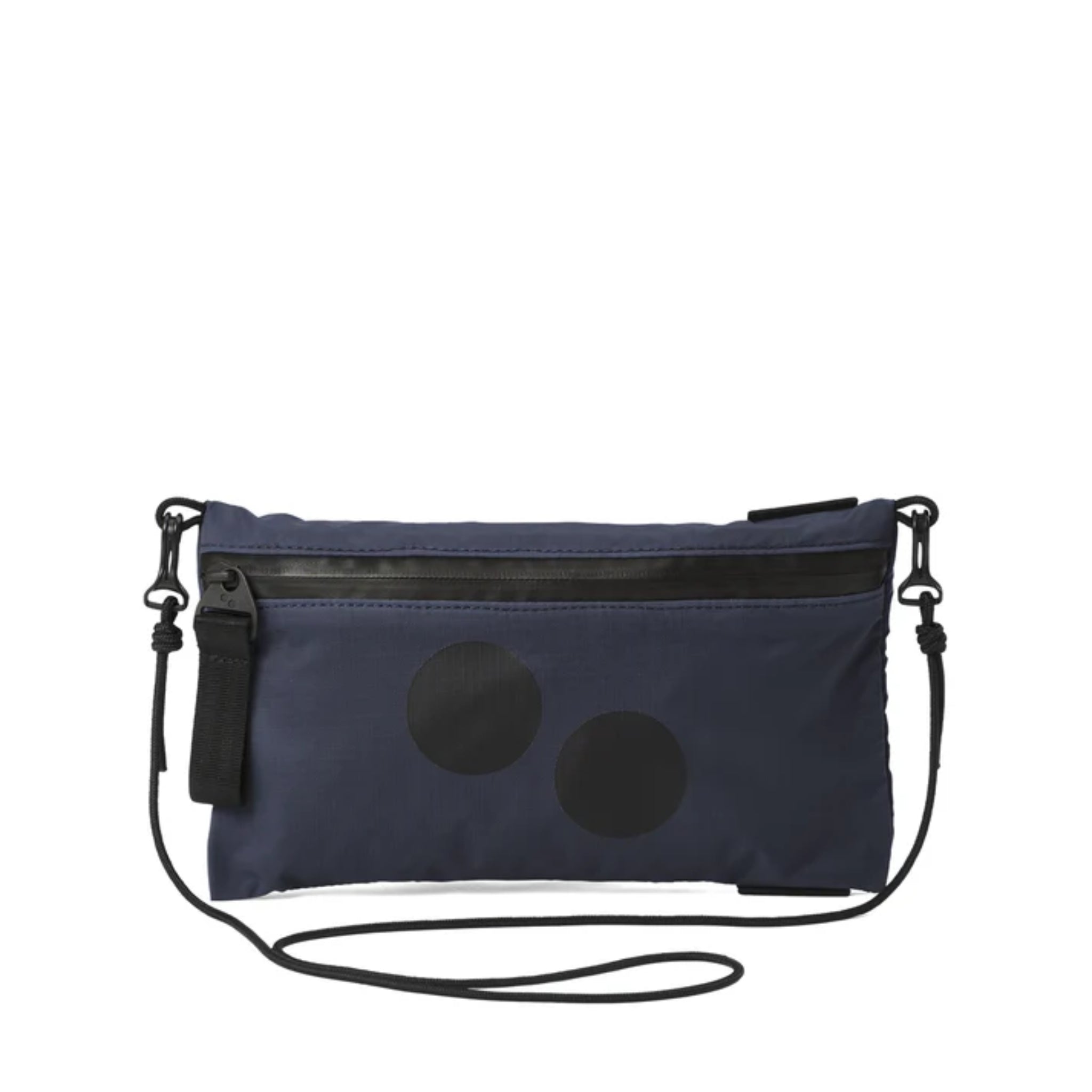 Eine kleine marineblaue Umhängetasche mit schwarzem Reißverschluss, schwarzem Riemen und zwei schwarzen Kreismustern auf der Vorderseite. Die Tasche ist einfach und rechteckig mit minimalen Details.