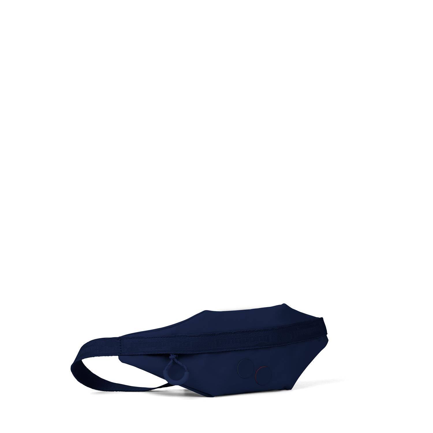Eine marineblaue Hüfttasche mit einfachem Reißverschluss und verstellbarem Gurt, die vor einem schlichten weißen Hintergrund steht.