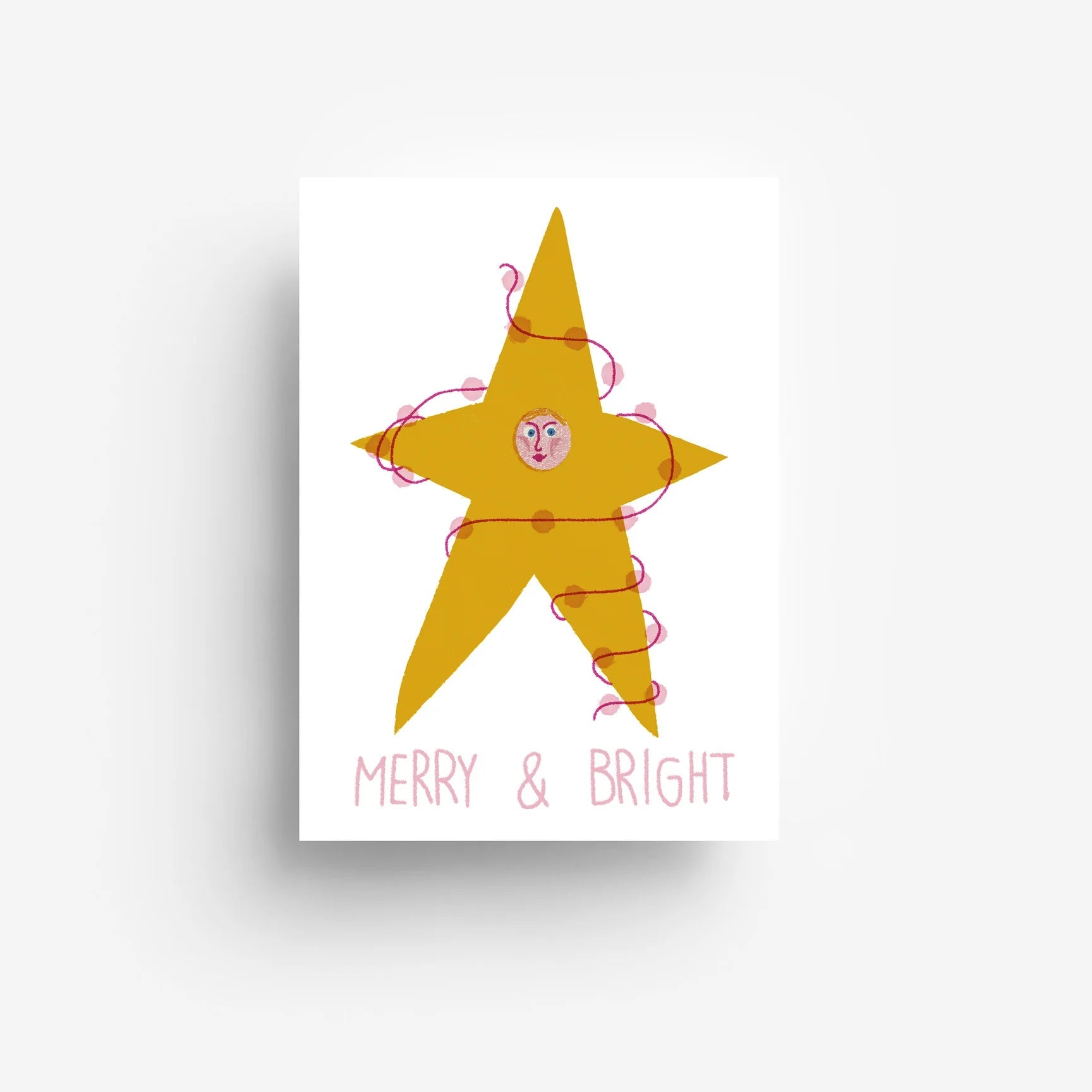 Ein gelber Stern mit einem Gesicht in der Mitte ist mit einem rosa Band umwickelt. Unterhalb des Sterns steht MERRY & BRIGHT in rosa Buchstaben auf weißem Hintergrund.