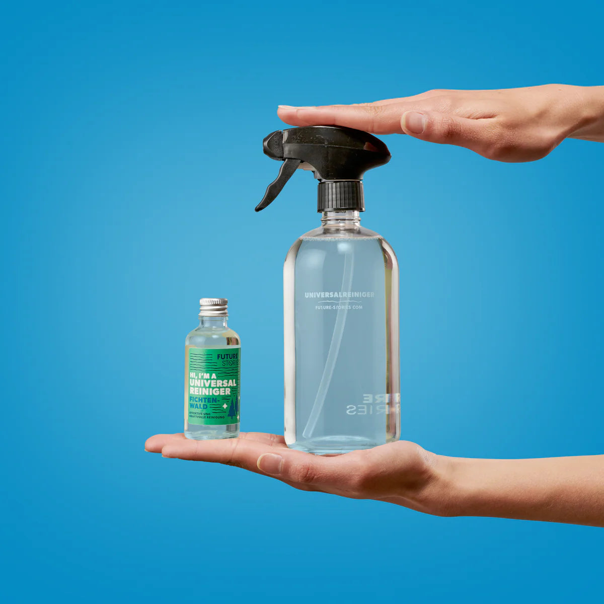 Eine Hand hält eine kleine Flasche mit konzentriertem Universalreiniger, während eine andere Hand eine größere Sprühflasche mit verdünntem Reiniger hält, beide vor einem blauen Hintergrund.