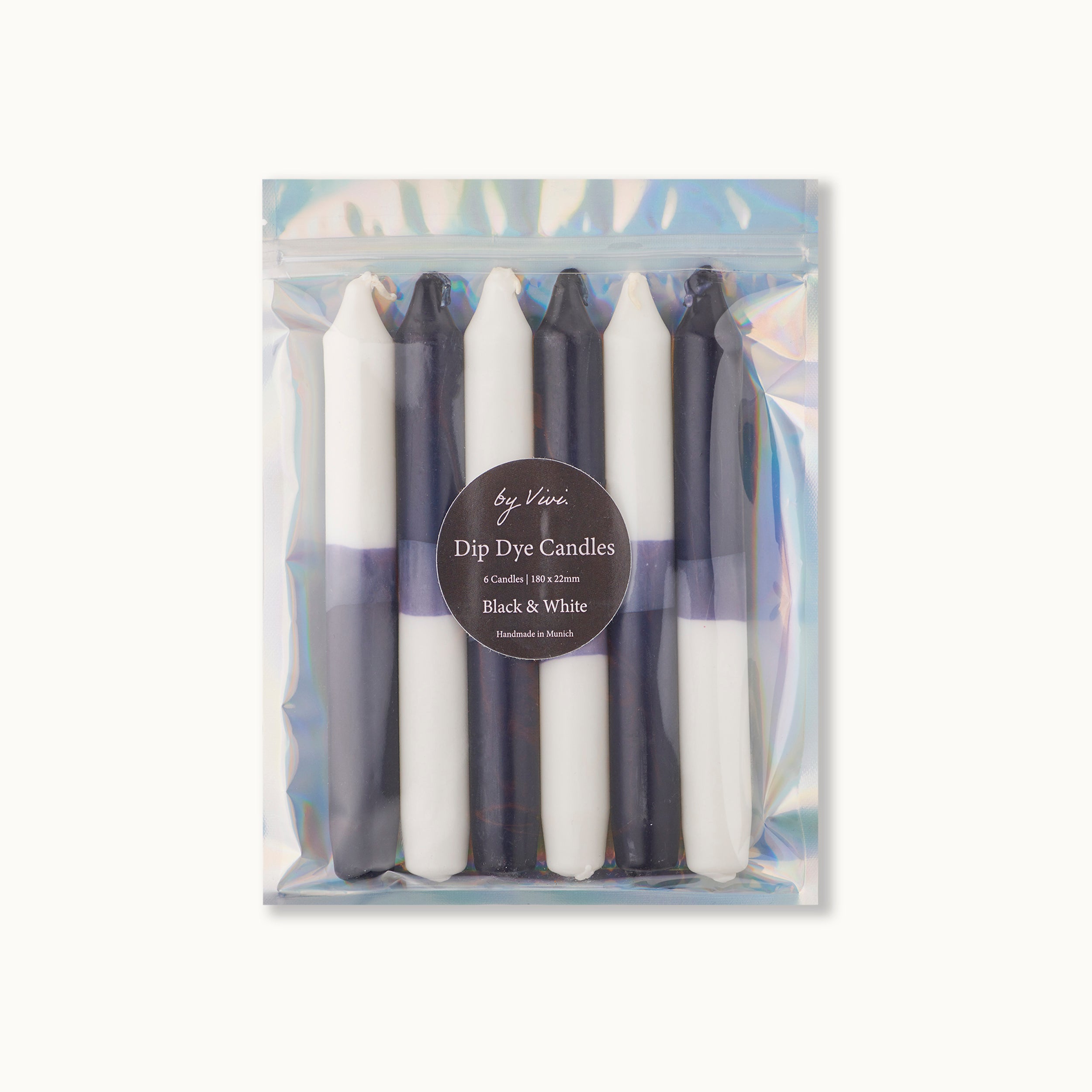 Ein wiederverschließbarer, irisierender Beutel mit sechs schwarzen und weißen Dip-Dye-Kerzen, die vertikal angeordnet sind. Auf dem Etikett steht: by Vivi, Dip Dye Candles, 6 Kerzen 10h Brenndauer, Black & White, Handmade in Munich.