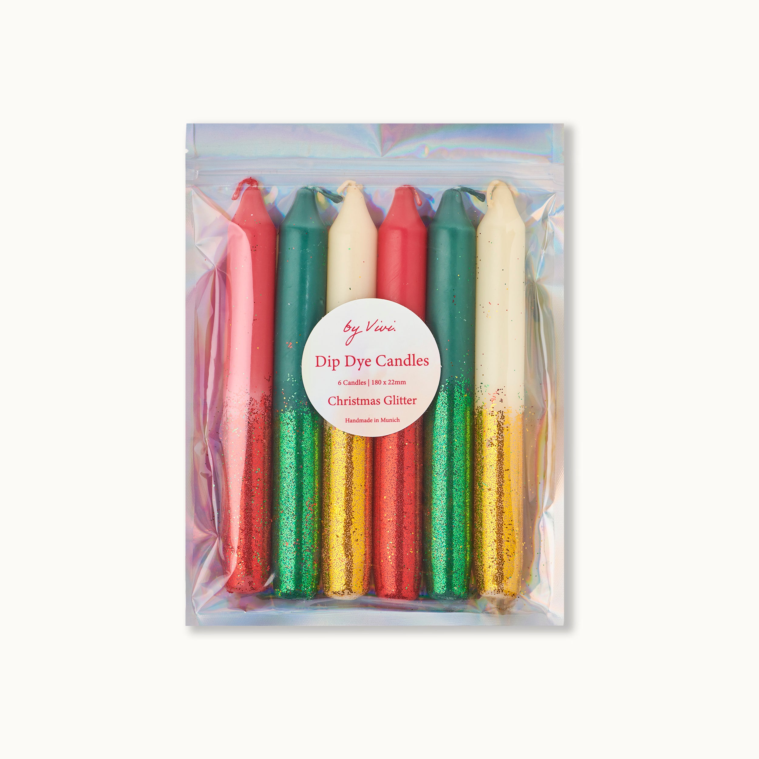 Ein Set von sechs Dip-Dye-Kerzen in den Farben Rot, Grün und Weiß mit goldenem und grünem Glitter auf den unteren Hälften, verpackt in einer glänzenden, schillernden Plastiktüte mit der Aufschrift Dip Dye Candles Christmas Glitter.
