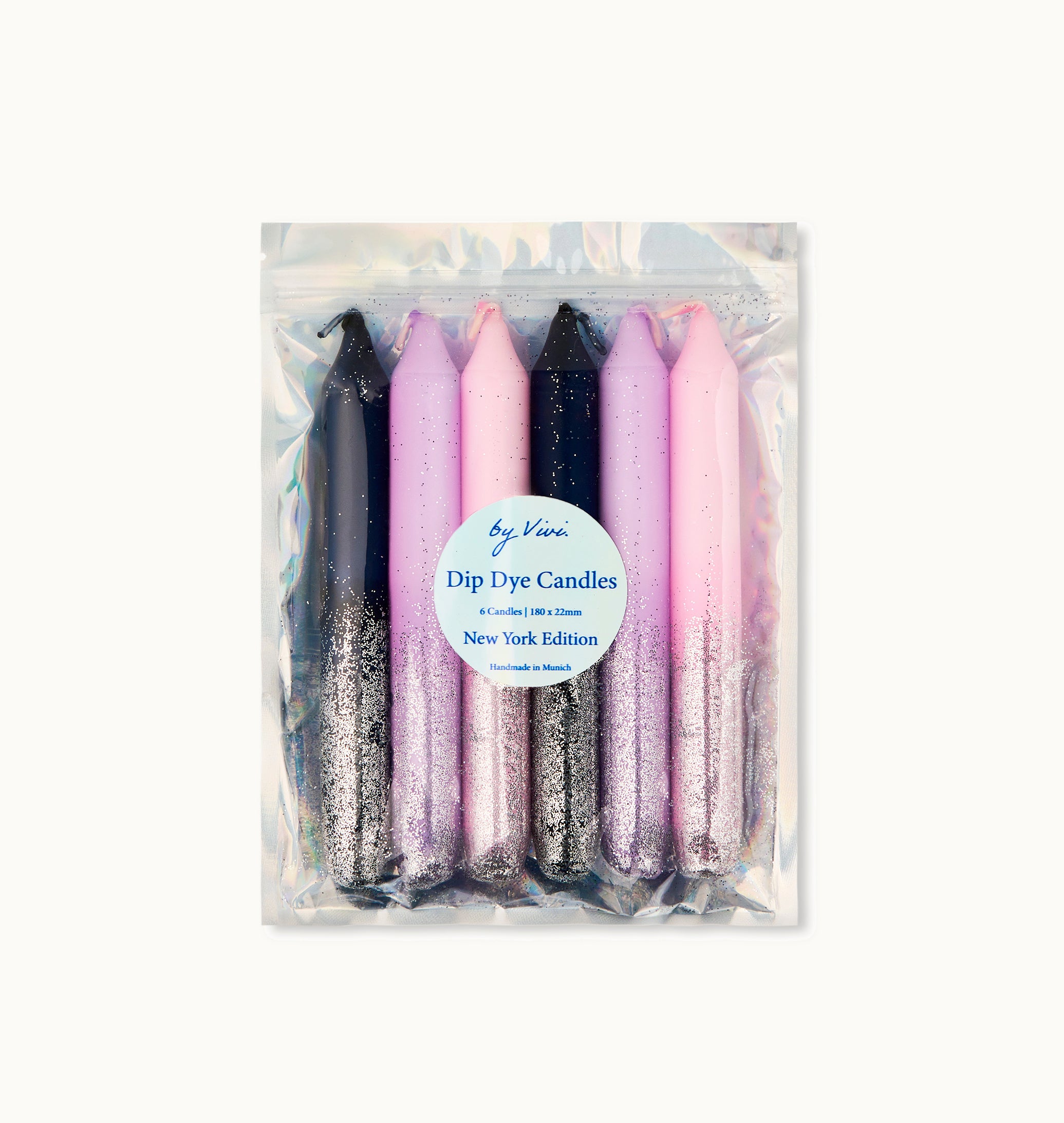 Ein Set mit sechs Dip-Dye-Kerzen in Schwarz-, Lila- und Rosatönen mit silbernem Glitter, verpackt in einem wiederverschließbaren Klarsichtbeutel mit der Aufschrift Dip Dye Candles, New York Edition.