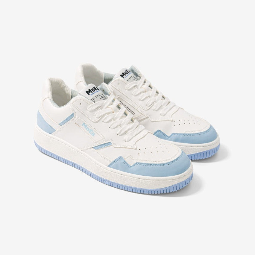 Ein Paar weiße Turnschuhe mit hellblauen Akzenten an den Seiten, an der Ferse und an den Zehen, mit weißen Schnürsenkeln und einer hellblauen und weißen Sohle, dargestellt auf einem hellen Hintergrund.