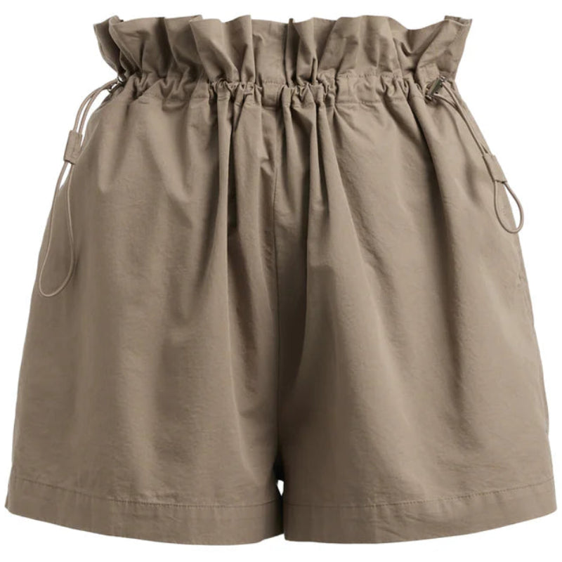 Beigefarbene Shorts mit Paperbag-Taille, gerafftem, gerüschtem Bund, Kordelzug und locker sitzenden Beinen auf einfarbig weißem Hintergrund.