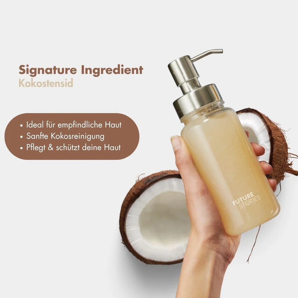 Eine Hand hält eine Pumpflasche mit der Aufschrift Future Stories neben einer halbierten Kokosnuss. Der Text hebt die Vorteile von Reinigungsmitteln auf Kokosnussbasis hervor: geeignet für empfindliche Haut, sanfte Reinigung und Hautschutz.