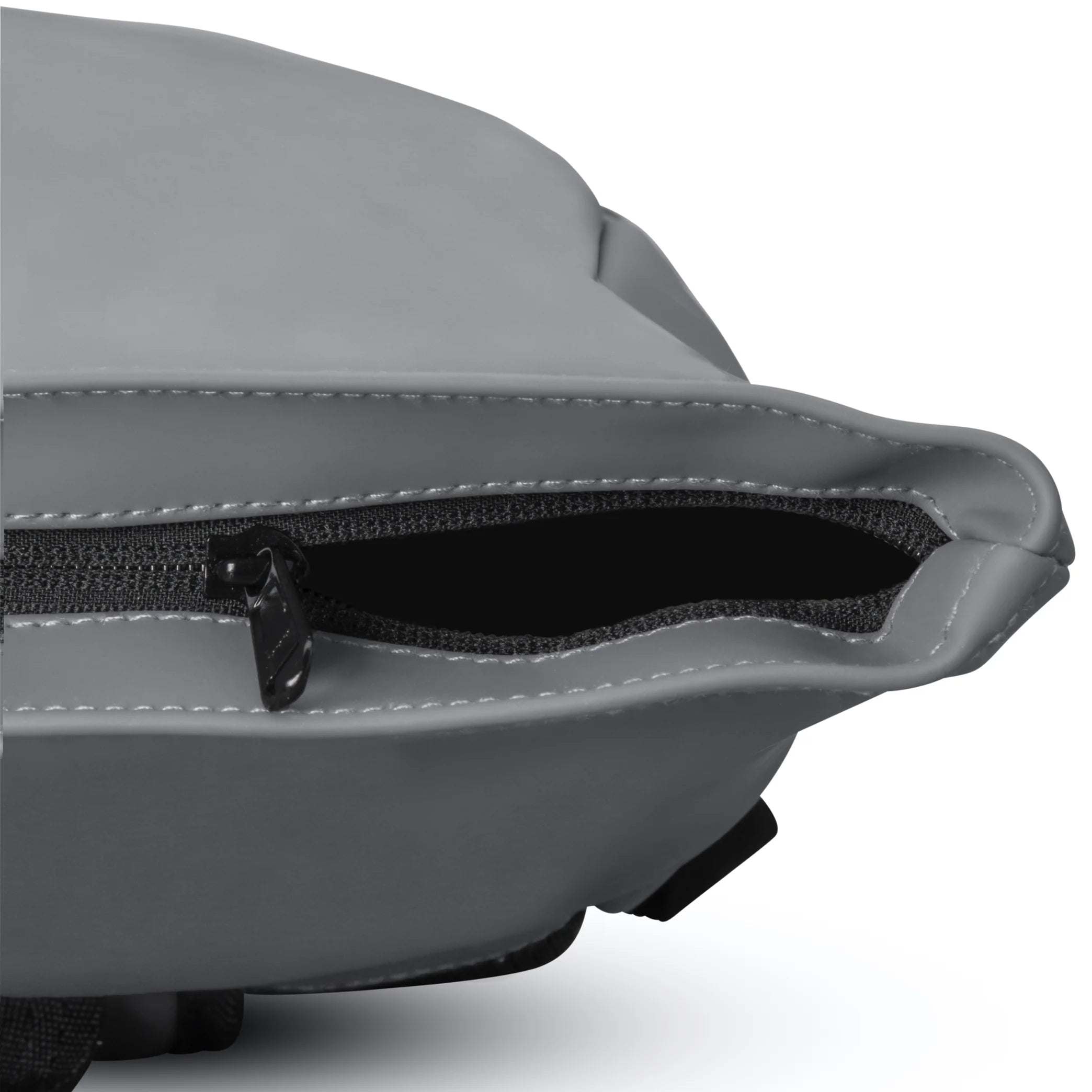 Nahaufnahme eines teilweise geöffneten Reißverschlusses an einer grauen Tasche, mit schwarzem Stofffutter im Inneren. Die Nähte um den Reißverschluss und den Rand der Tasche sind sichtbar.