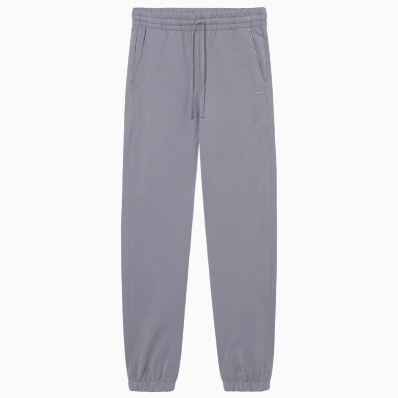 Hellgraue Jogginghose mit elastischem Bund, Kordelzug, Seitentaschen und elastischen Bündchen an den Knöcheln auf einfarbig weißem Grund.