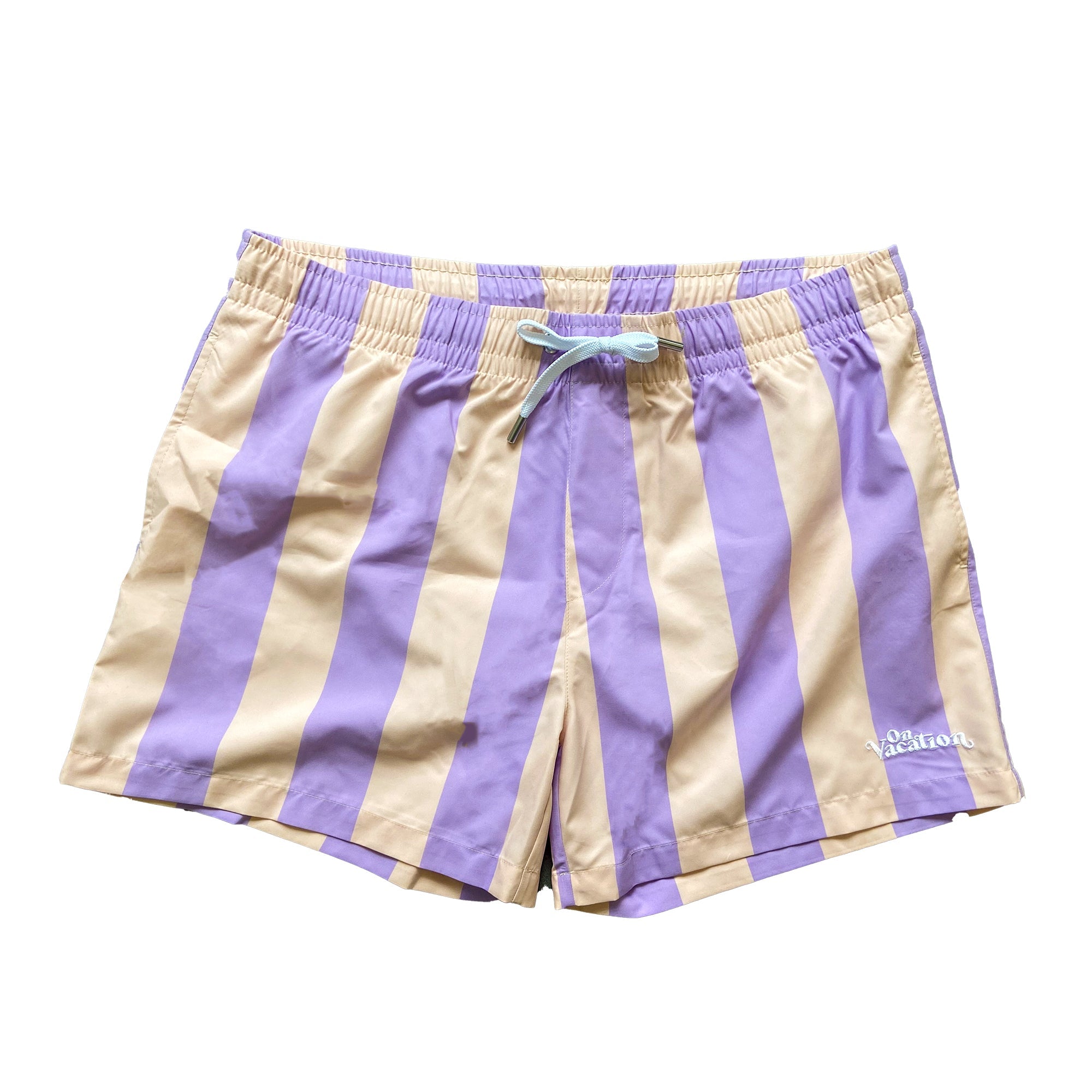 Ein Paar Badeshorts mit vertikalen lavendelfarbenen und beigen Streifen, einem elastischen Bund mit hellblauem Kordelzug und einem kleinen weißen Logo am unteren linken Bein.