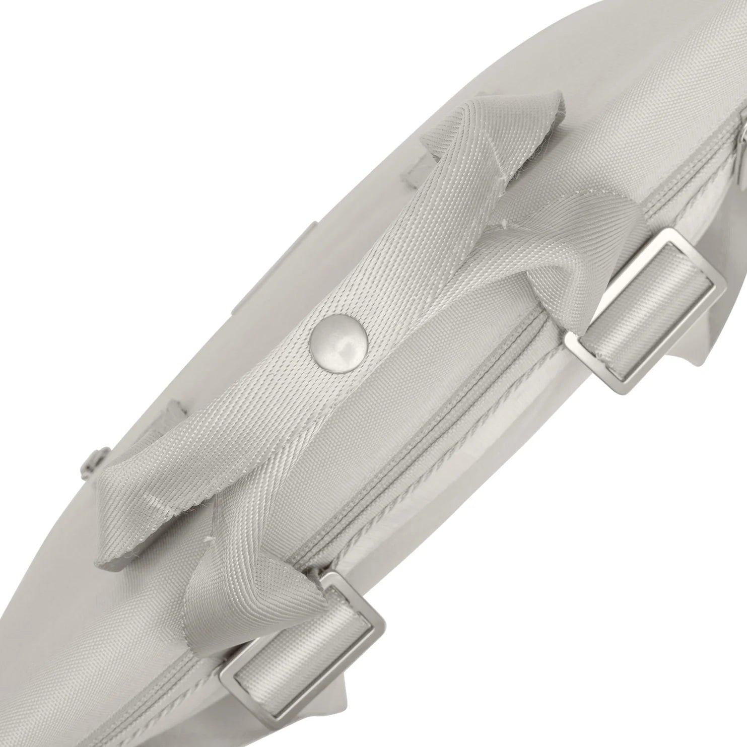 Nahaufnahme eines hellgrauen Stoffriemens mit Metalldruckknopf und zwei verstellbaren Schnallen, der an einer passenden Tasche oder einem Koffer befestigt ist.