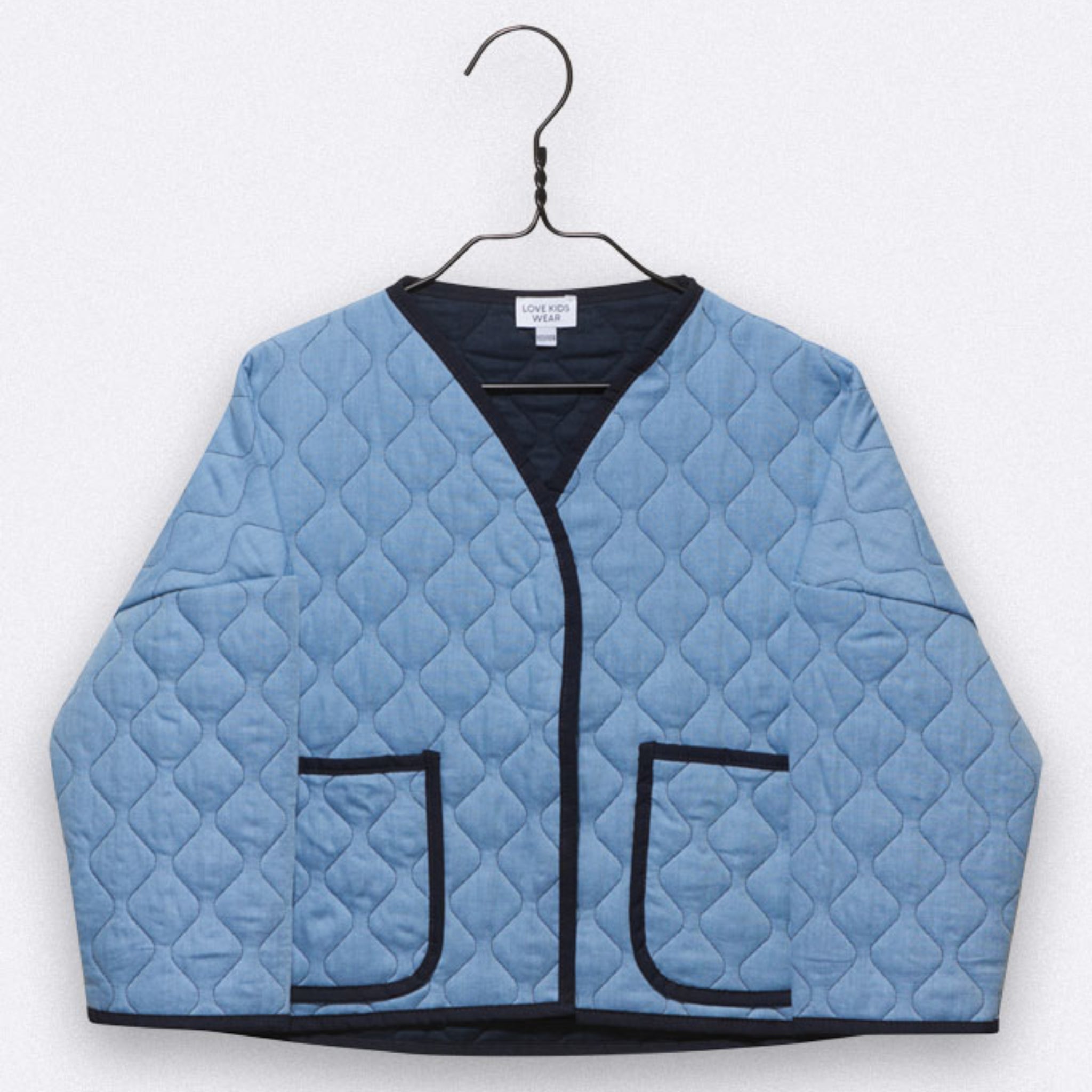 Hellblaue Steppjacke mit schwarzem Besatz, V-Ausschnitt, zwei Vordertaschen, auf einem schwarzen Kleiderbügel vor einem schlichten hellen Hintergrund.