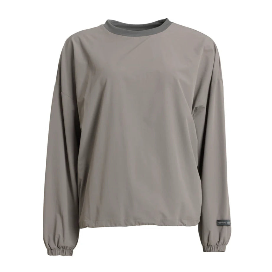 Ein schlichter, langärmeliger, hellbraungrauer Pullover mit Rundhalsausschnitt und elastischen Bündchen. Der Stoff scheint glatt und leicht zu sein. Auf dem linken Ärmel in der Nähe des Handgelenks befindet sich ein kleines schwarzes Etikett.