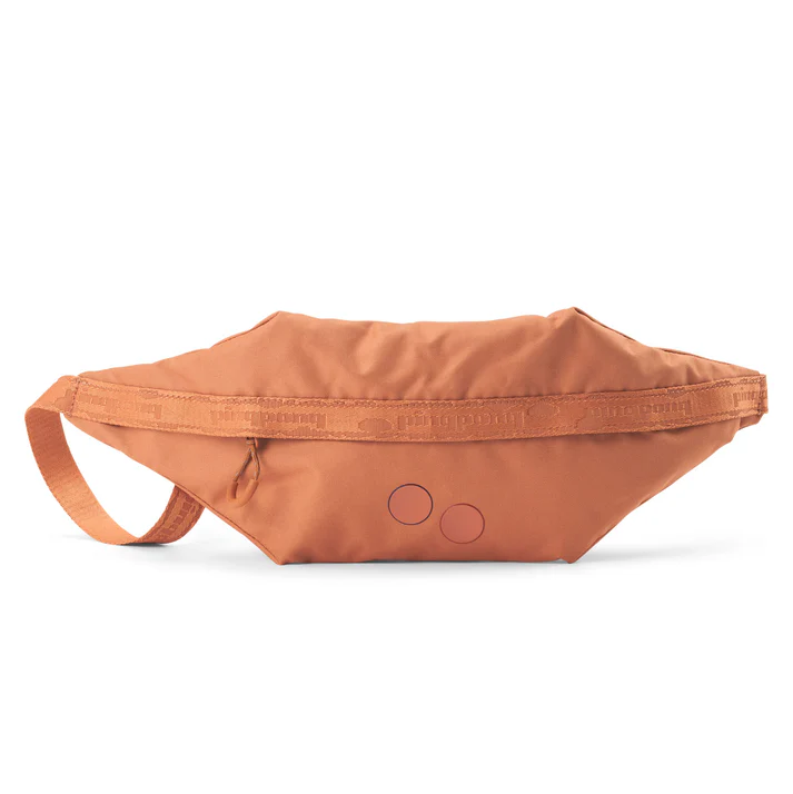 Eine orangefarbene Gürteltasche aus Stoff mit einem Reißverschluss und einem verstellbaren Riemen auf weißem Hintergrund. Zwei kleine Kreise sind auf der Vorderseite der Tasche aufgedruckt.