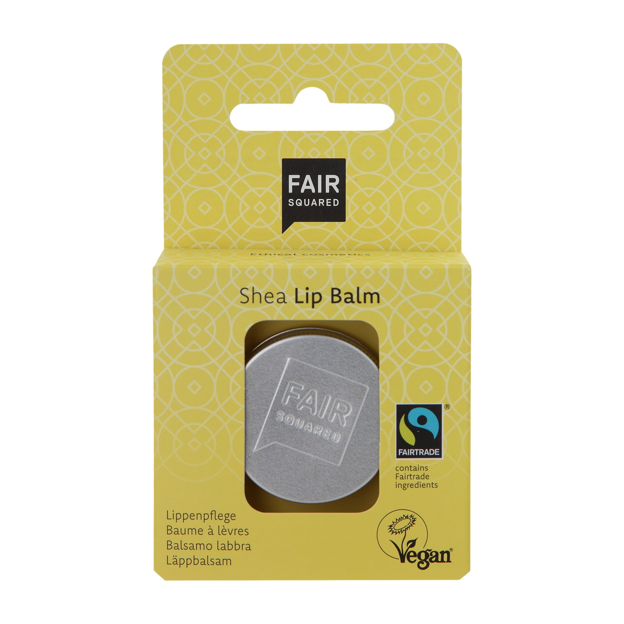 Gelbe Fair Squared Shea Lip Balm Verpackung mit einer runden silbernen Dose im Inneren. Die Verpackung enthält Fairtrade- und Vegan-Logos sowie Text in mehreren Sprachen.
