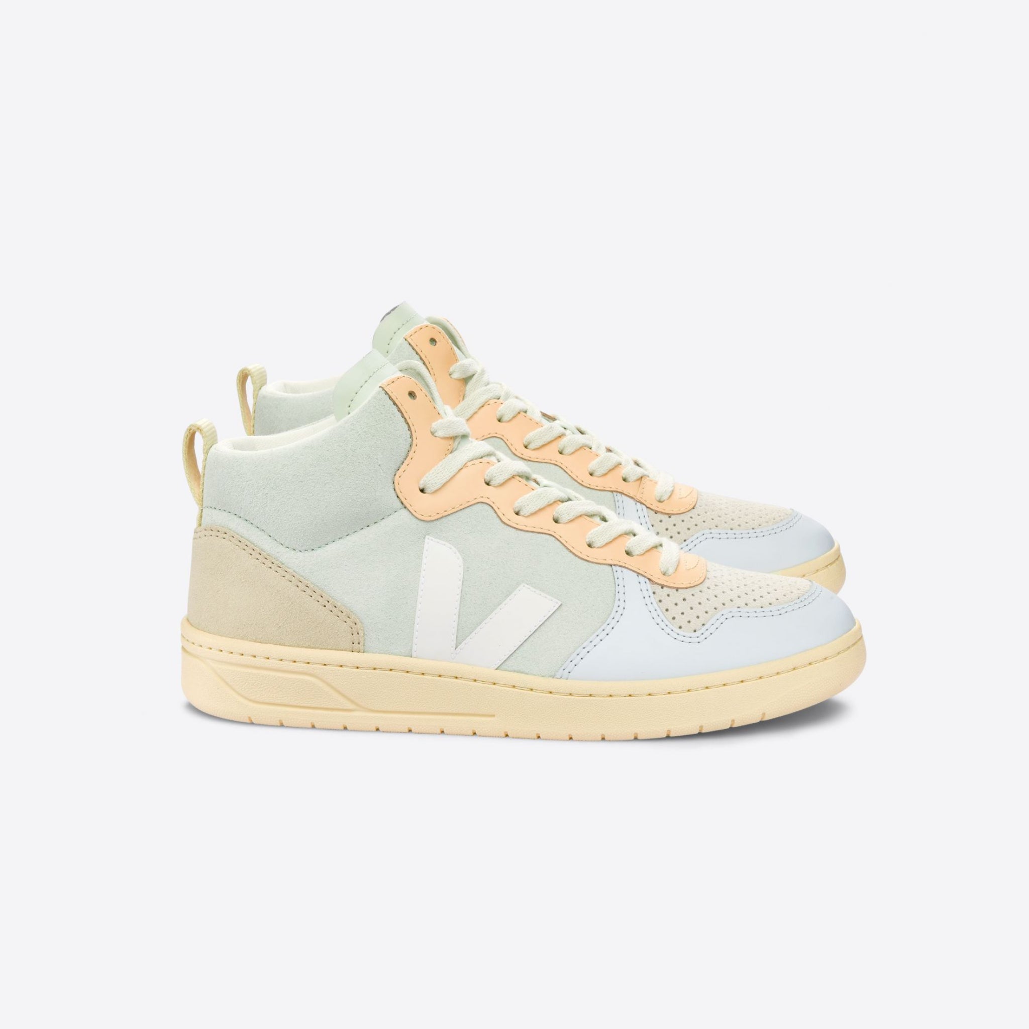 Beige, hellgrüne und weiße Sneakers mit hohem Schaft und stilisiertem "V" seitlich auf einem grauen Hintergrund.