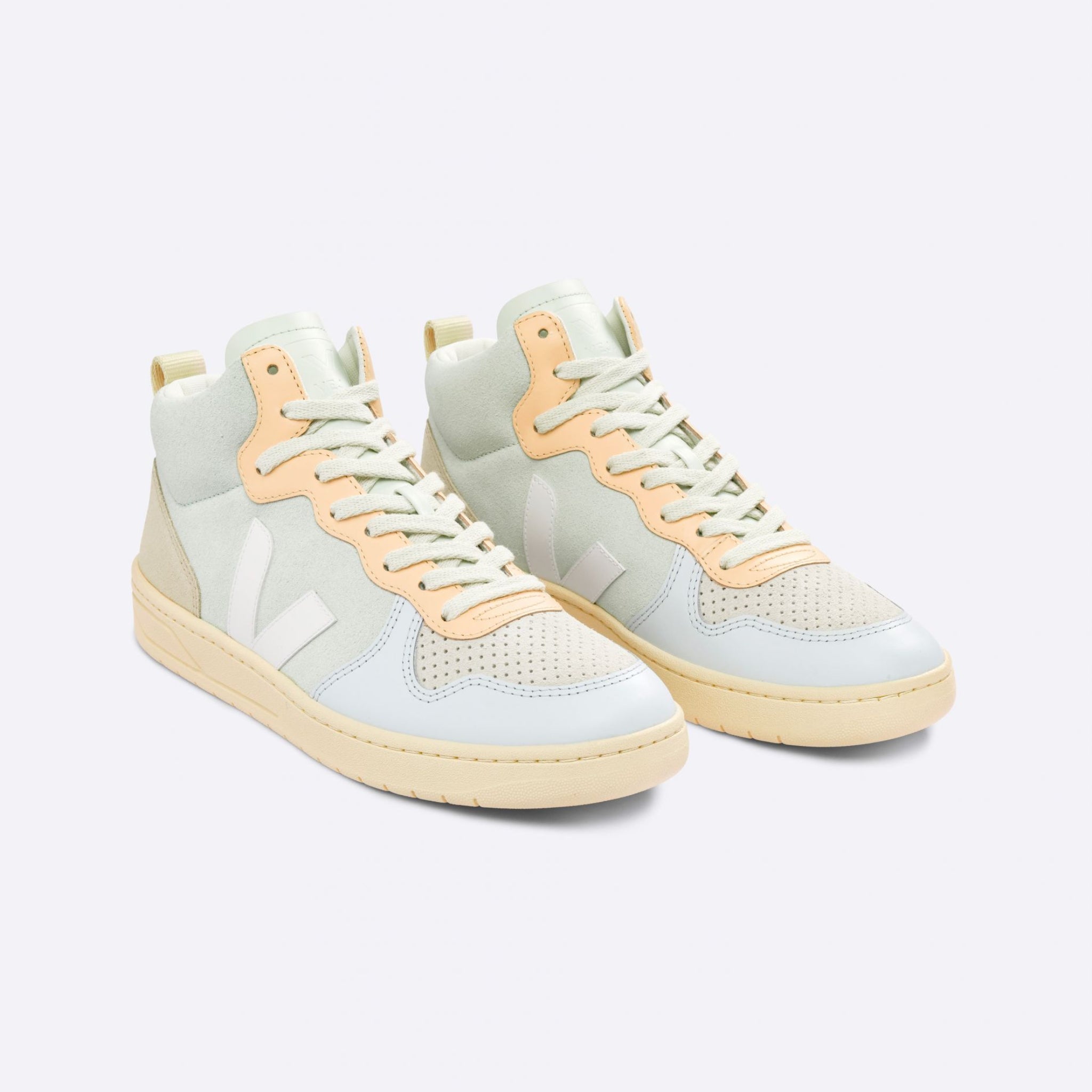 Zwei beigefarbene High-Top-Sneaker mit pastellfarbenen Details und weißem Logo auf der Seite auf weißem Hintergrund.