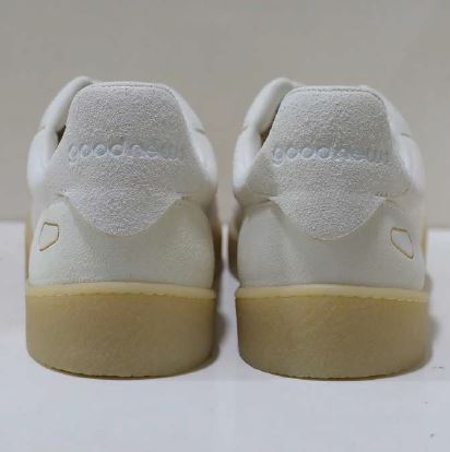 Rückansicht eines weißen Turnschuhpaares mit beiger Sohle, auf einem weißen Hintergrund.