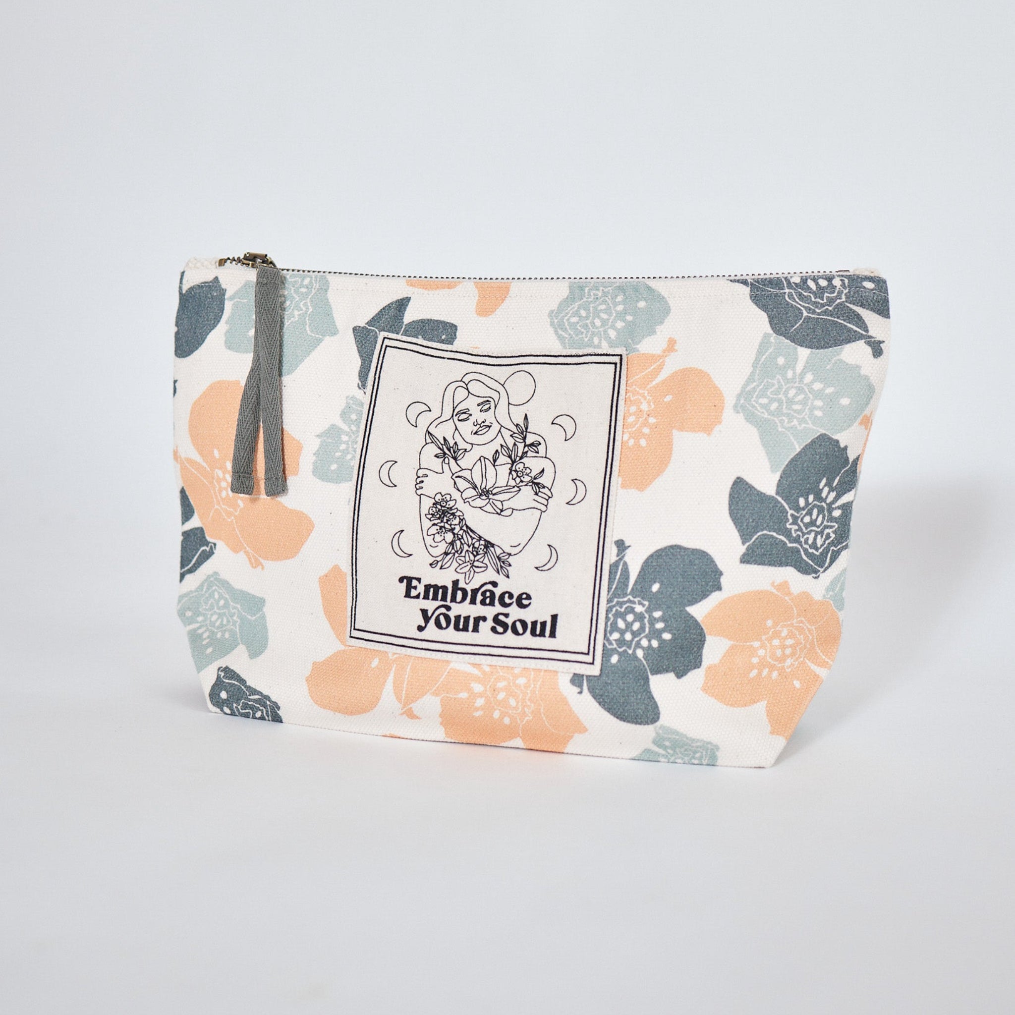 Kosmetiktasche mit floralen Mustern und der Aufschrift "Embrace Your Soul" in Schwarz, mit Reißverschluss und Quaste.