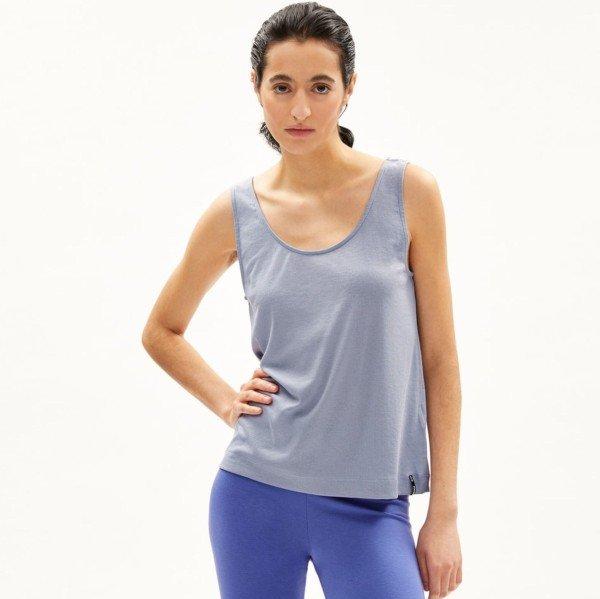 Person in a blue tank top and pants standing against a plain white background.