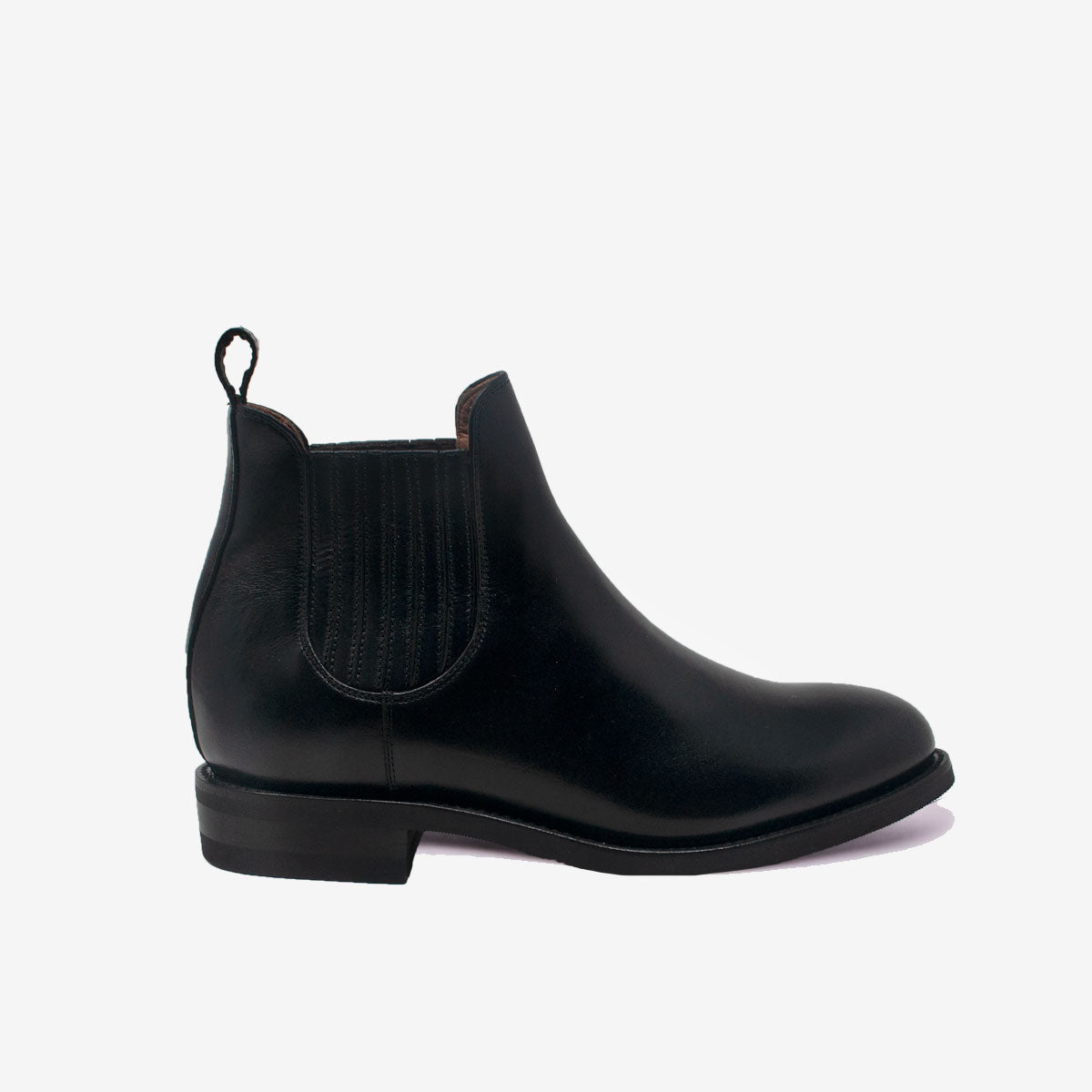 Ein schwarzer Chelsea-Stiefel aus Leder mit elastischen Seiteneinsätzen, einer Zuglasche hinten und einem niedrigen Absatz, der im Profil auf einem schlichten weißen Hintergrund gezeigt wird.