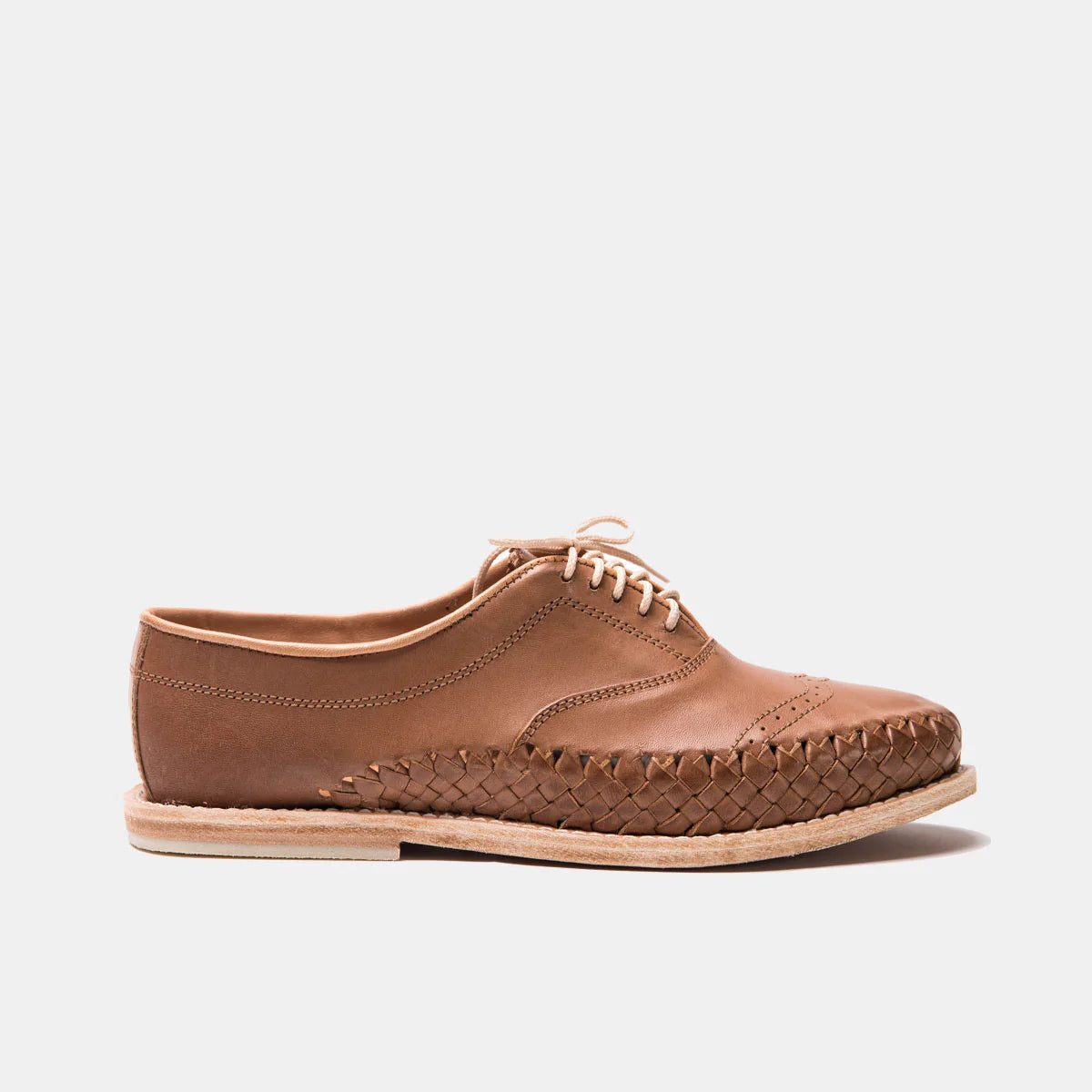 Ein brauner Lederschnürschuh mit einem gewebten Muster entlang der unteren Seite und der Vorderseite, dargestellt auf einem schlichten weißen Hintergrund.
